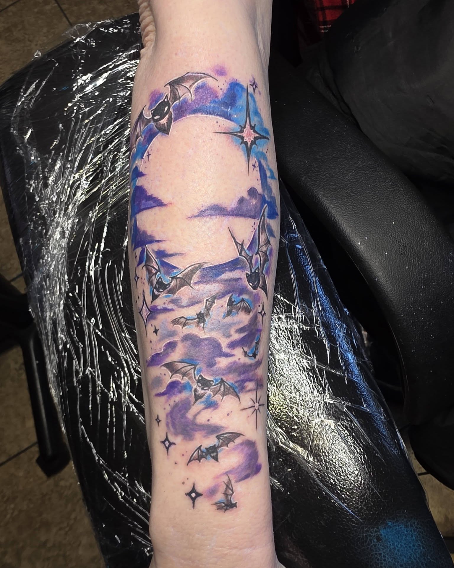 Night sky with bats watercolor tattoo on the forearm by Jessica DarkRabbit