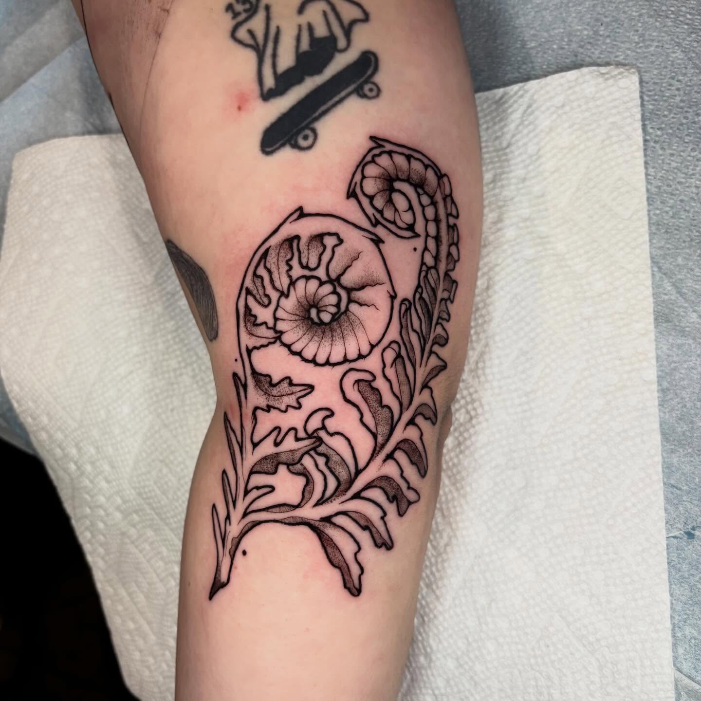 Floral design black and grey tattoo on the forearm by Emmy Gallagher
