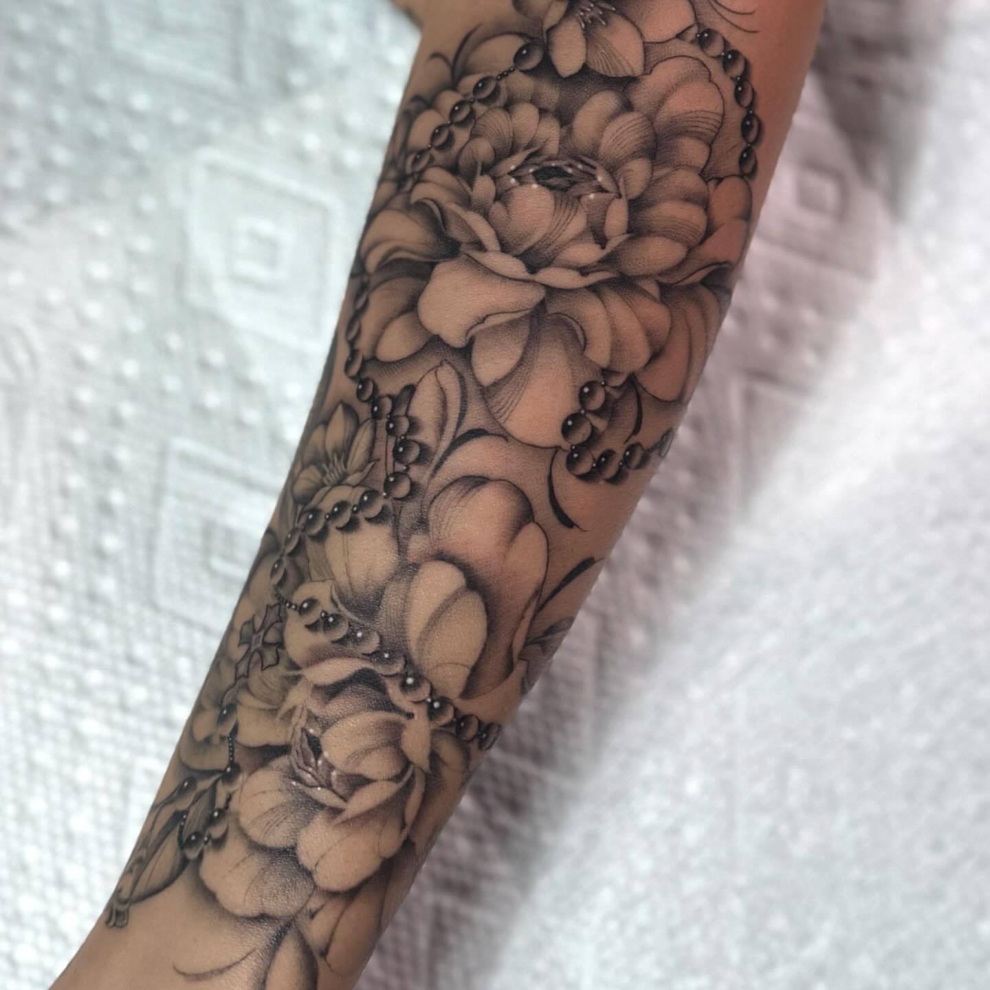 Floral bouquet realism tattoo on the forearm by Jas Knight