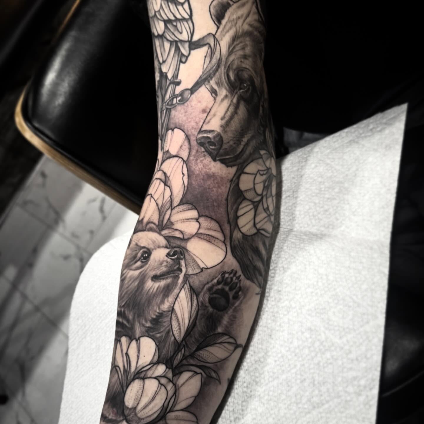 Dog and flowers realism tattoo on the forearm by Keith Smith