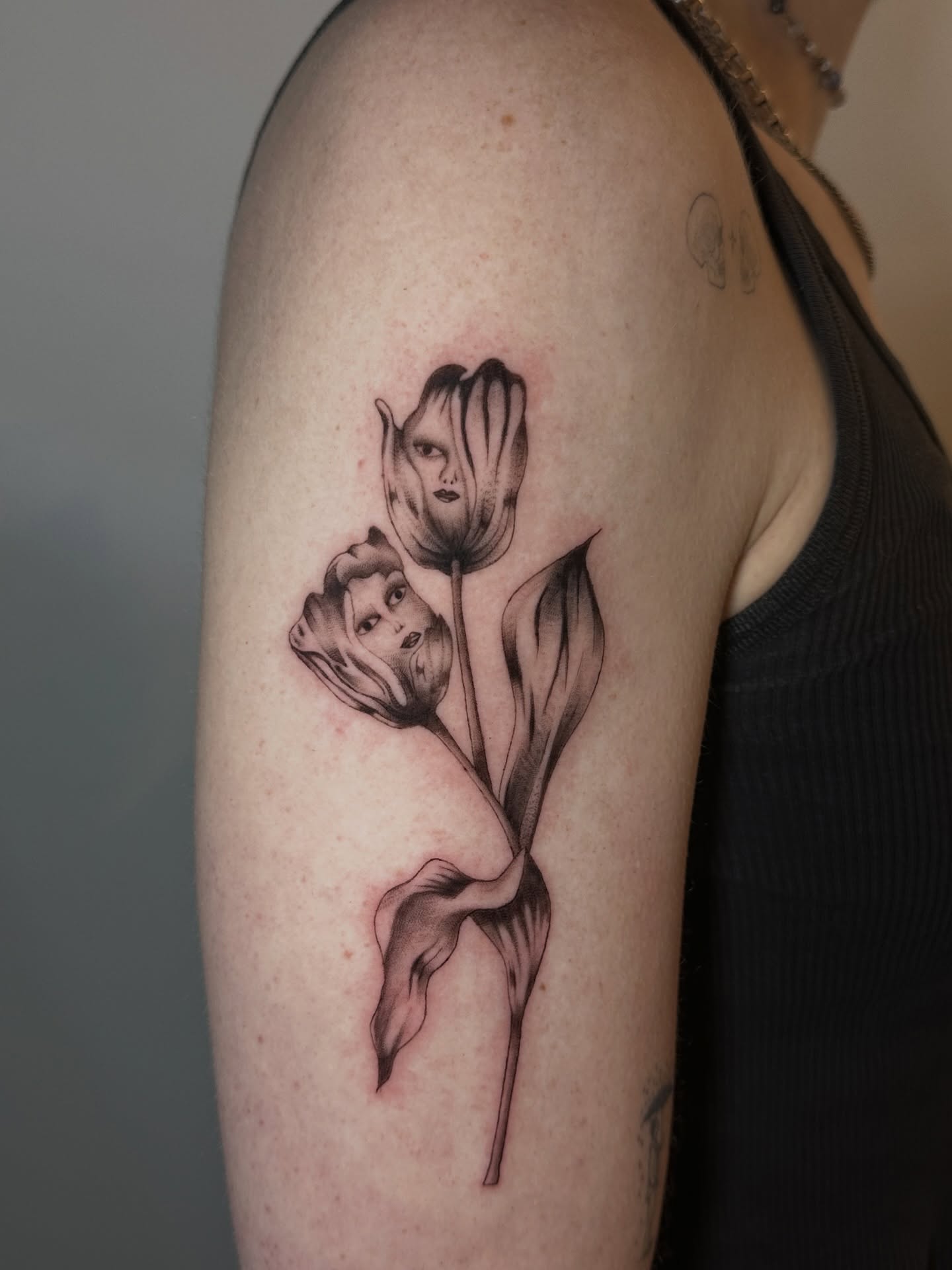 Tulips and faces realism tattoo on the upper arm by macie ❥ austin tattoo artist, Austin, Texas