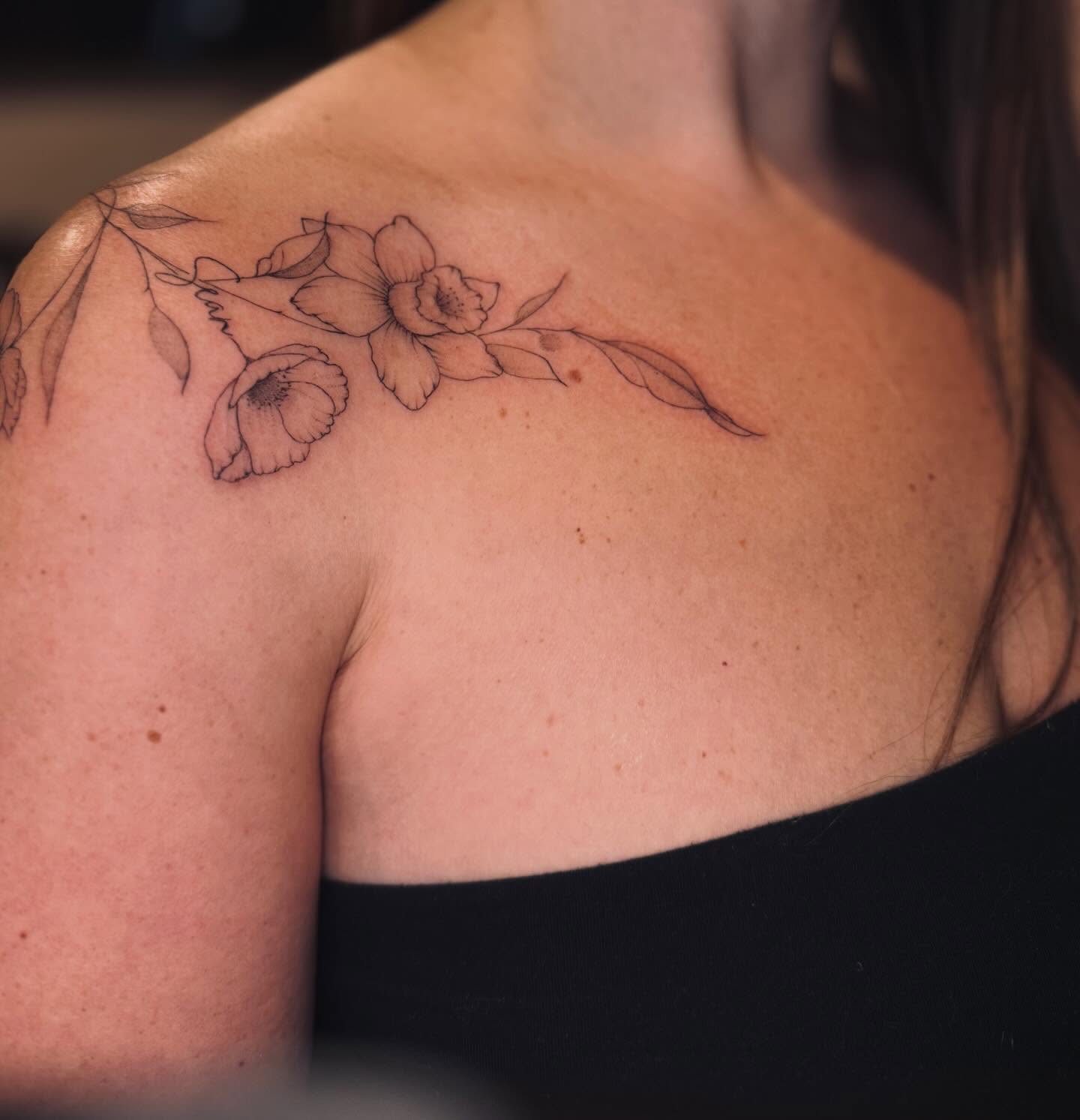 Flowers fine line tattoo on the shoulder by Ashley Pilgreen