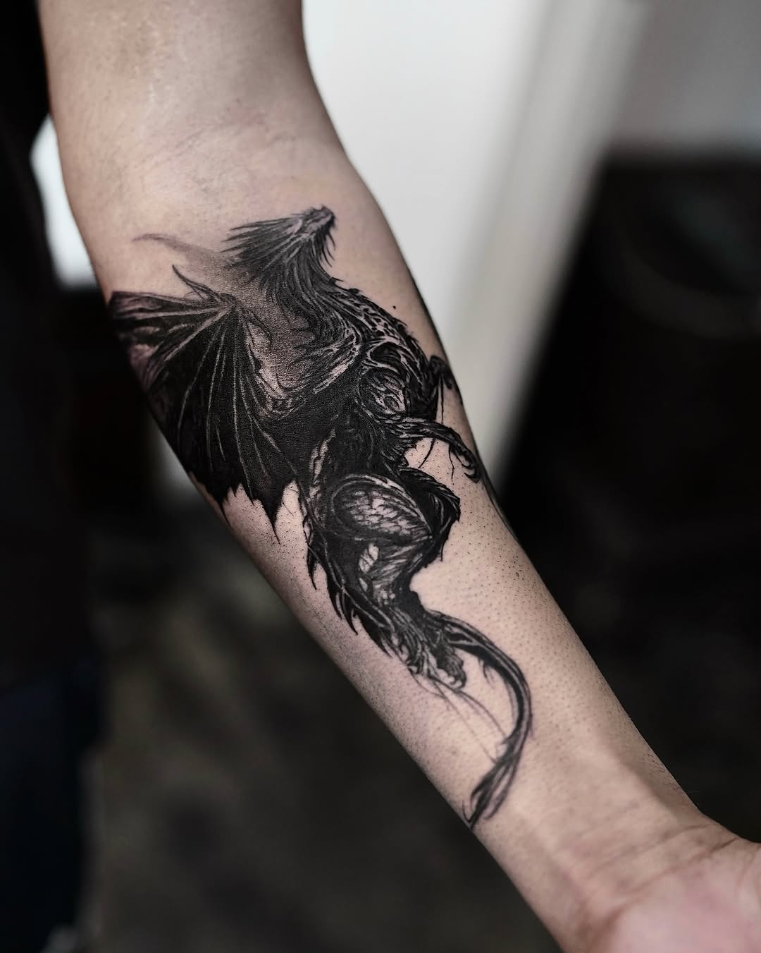 Dragon blackwork tattoo on the forearm by Gun