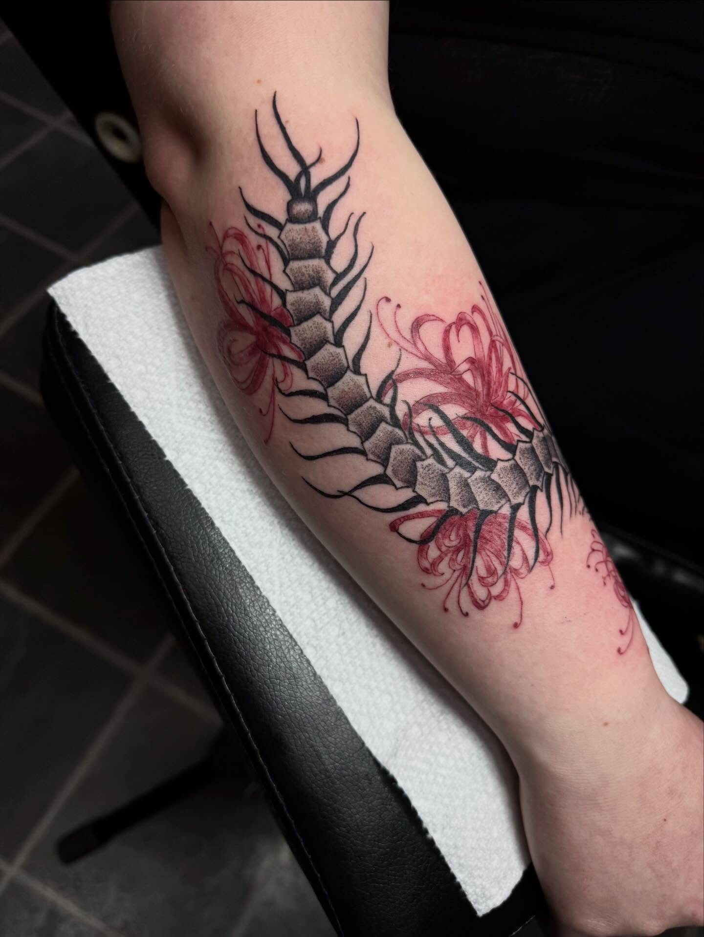 Centipede and flowers black and grey tattoo on the forearm by olivia reed