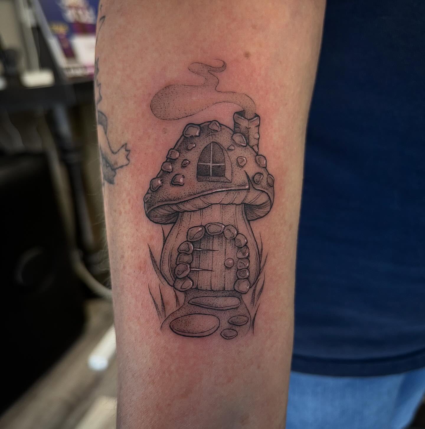 Mushroom house dotwork tattoo on the forearm by Hailey Nicole
