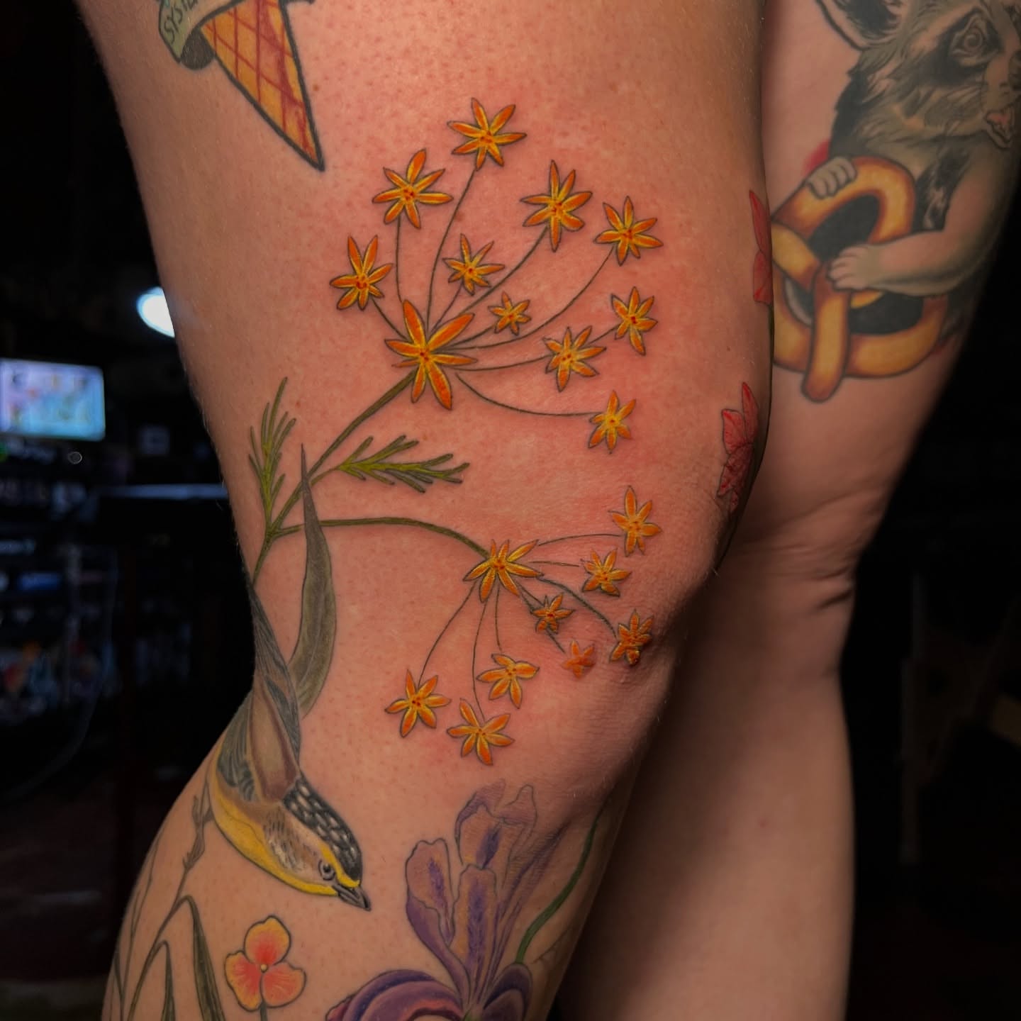 Orange flowers new school tattoo on the thigh by Jen Rahman
