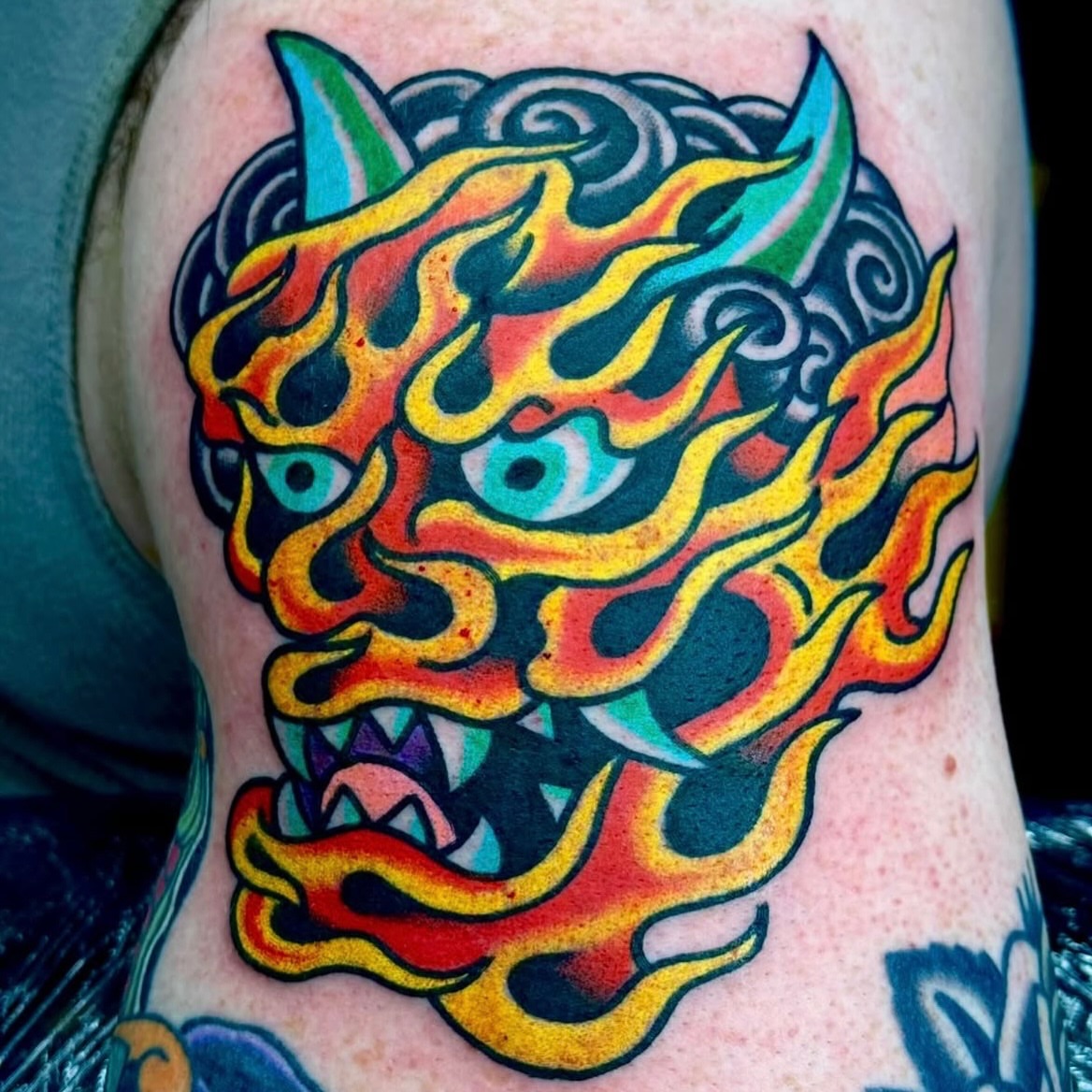 Flaming dragon head American traditional tattoo on the thigh by Sam Hambrick, Watchung NJ