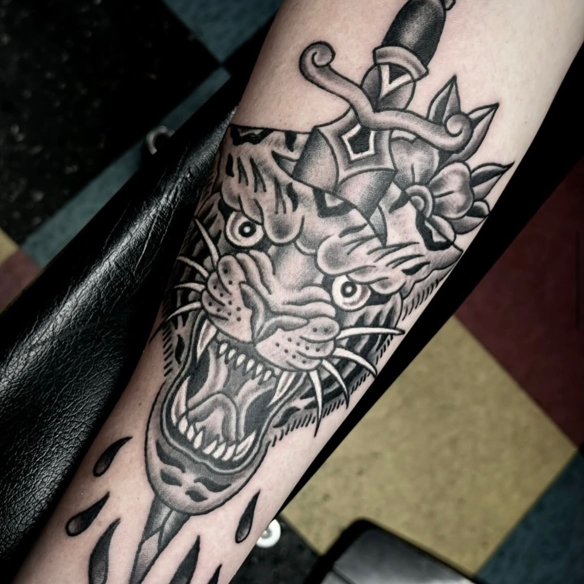 Tiger head with dagger American traditional tattoo on the forearm by Sam Hambrick, Watchung NJ