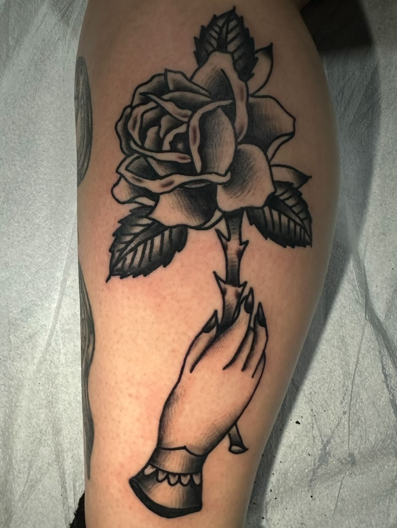 Rose American traditional tattoo on the thigh by Stephen Galena