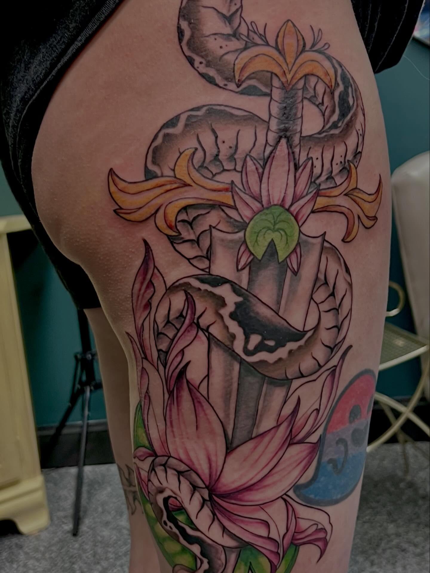 Lotus and snake American traditional tattoo on the thigh by Callie πͺ