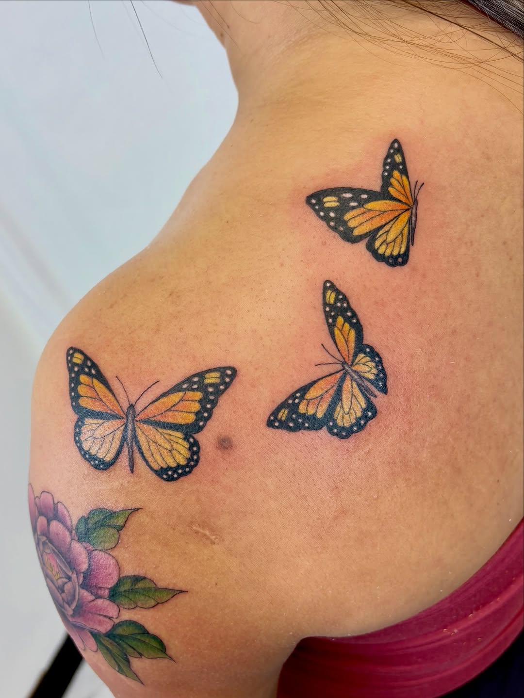 Monarch butterflies and peony fine line tattoo on the shoulder by Bianca Cattapan