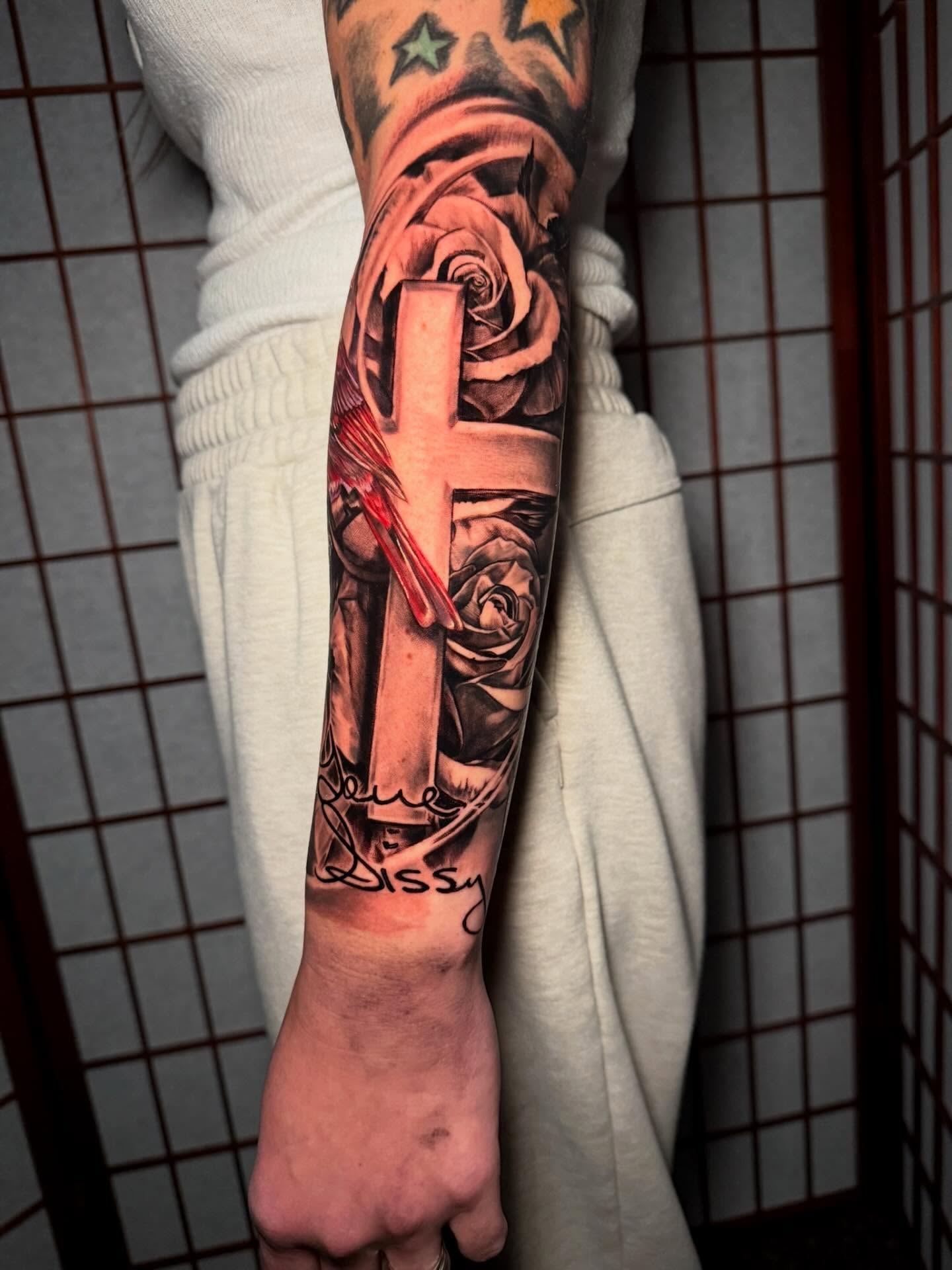 Cross and roses realism tattoo on the forearm by Johnny Scillieri