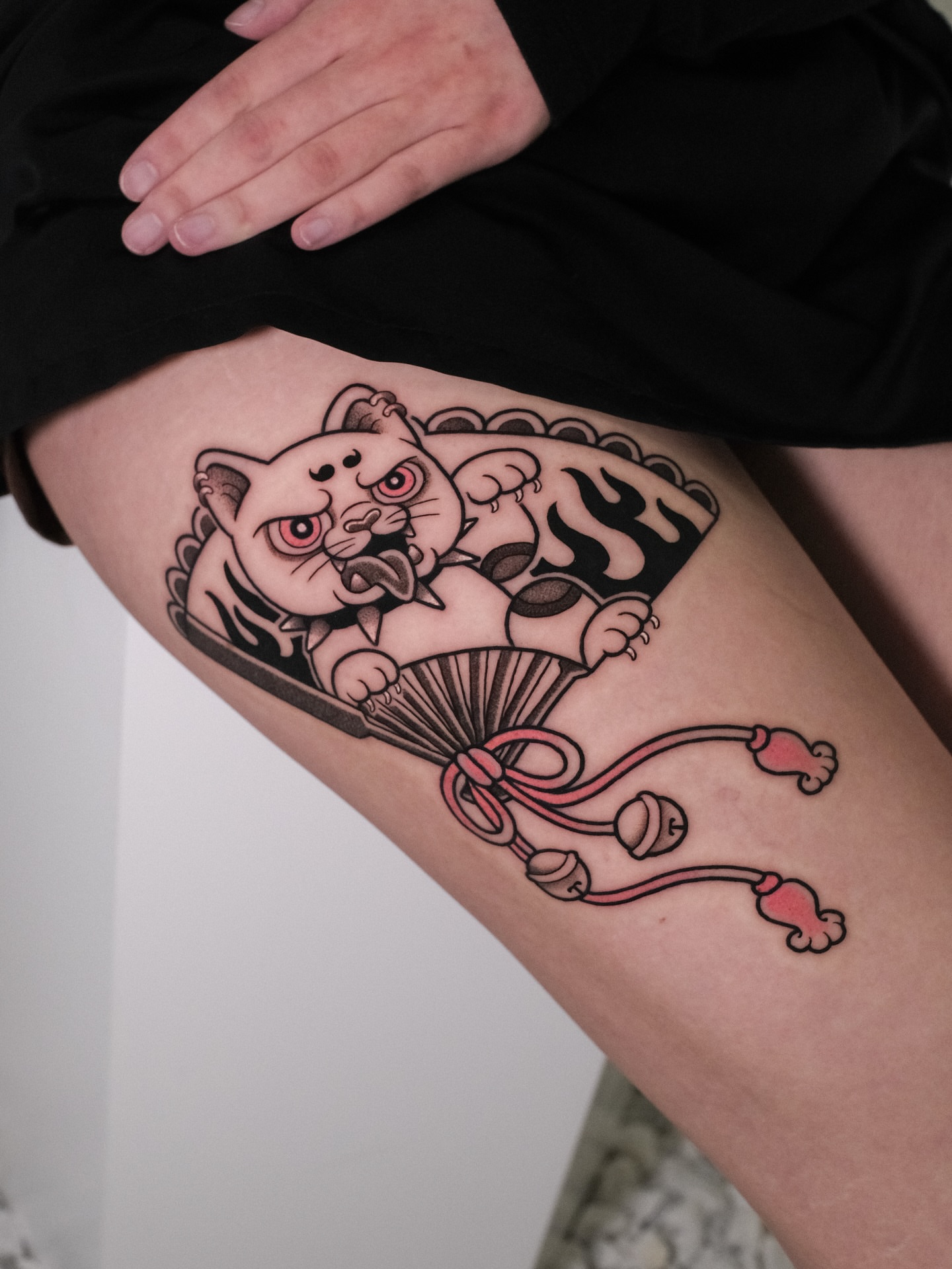 Cat with fan American traditional tattoo on the thigh by seattle tattoo artist
