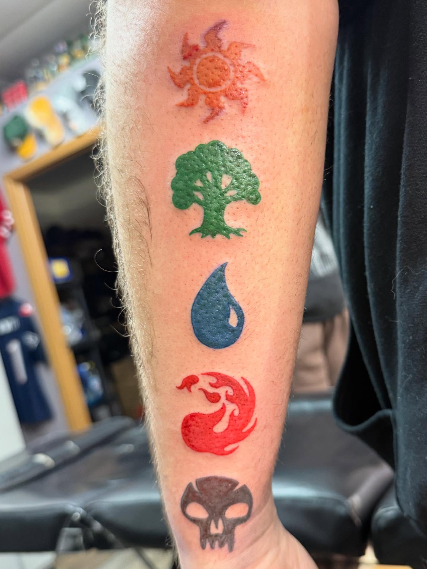 Elemental symbols dotwork tattoo on the forearm by Hunter Beyer