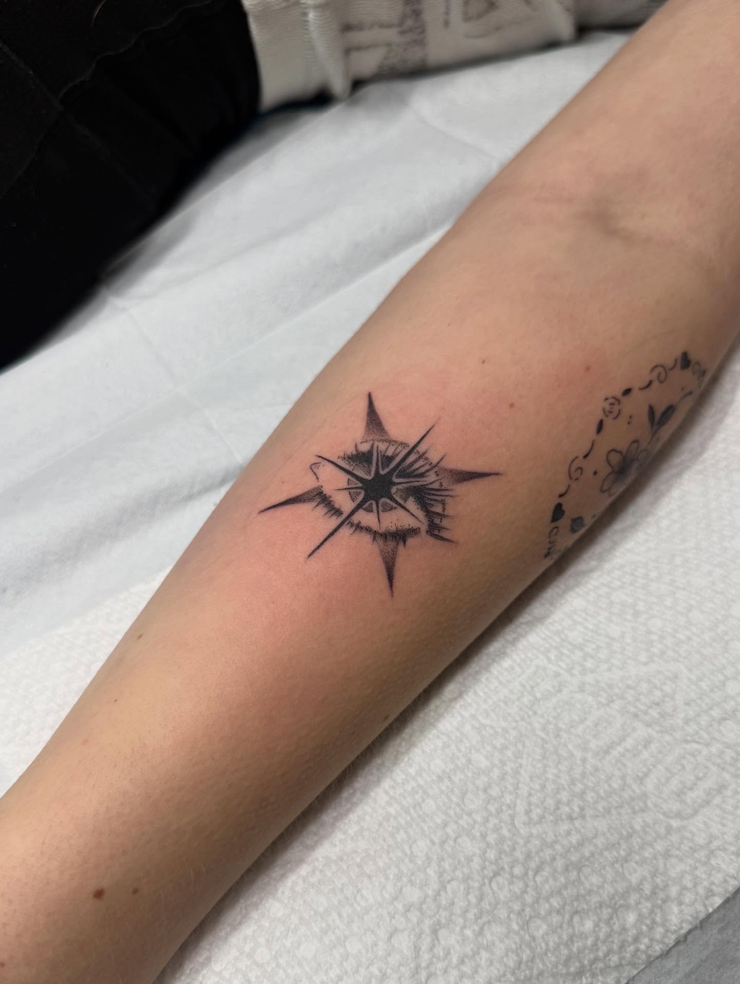 Compass star black and grey tattoo on the forearm by Maddie Jo DeYoung