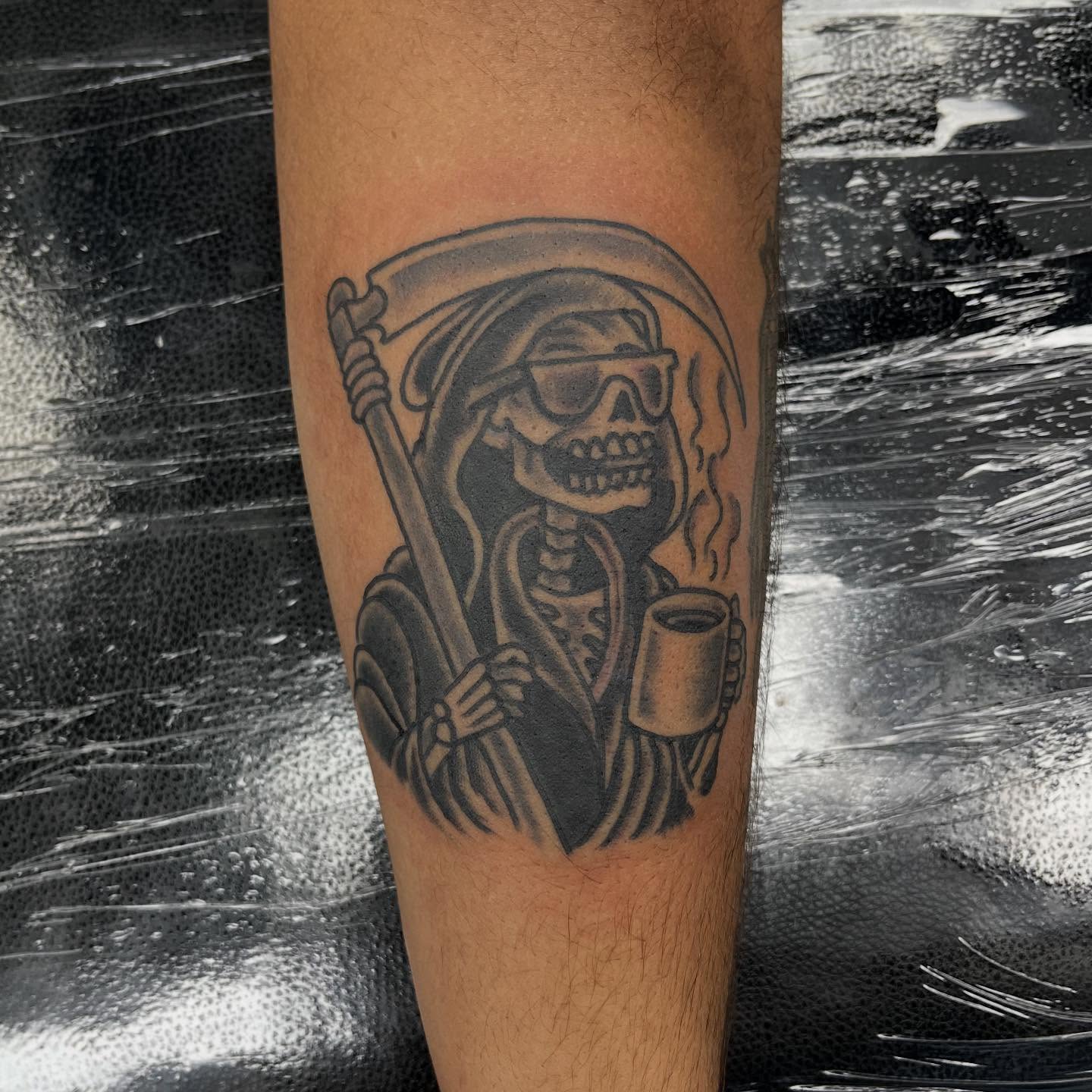 Reaper drinking coffee black and grey tattoo on the forearm by Franky Sharpz