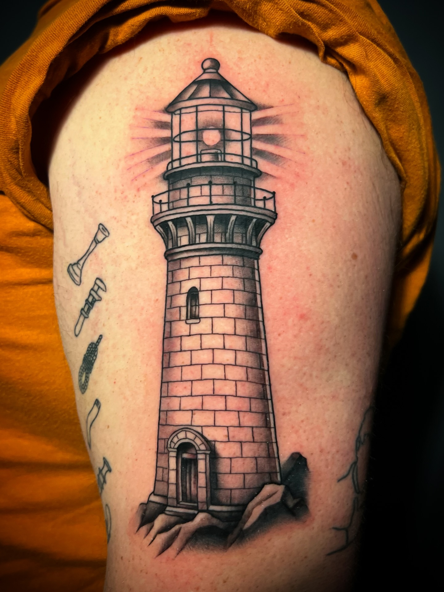 Lighthouse black and grey tattoo on the upper arm by Michael Munter, Philadelphia, Pennsylvania