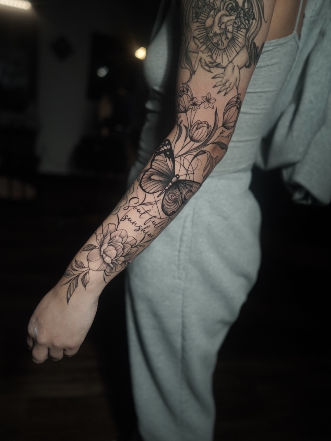 Butterfly and flowers black and grey tattoo on the forearm by Niko Hosk Cataldo
