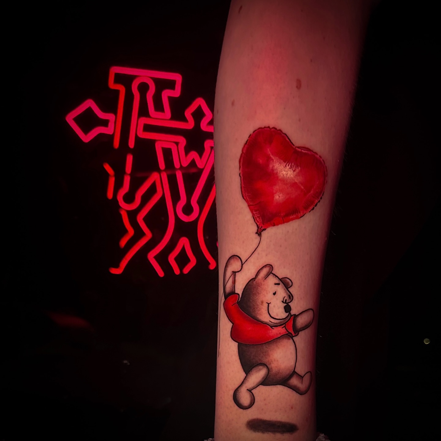 Winnie the Pooh with heart balloon realism tattoo on the forearm by Ryan Hindenach