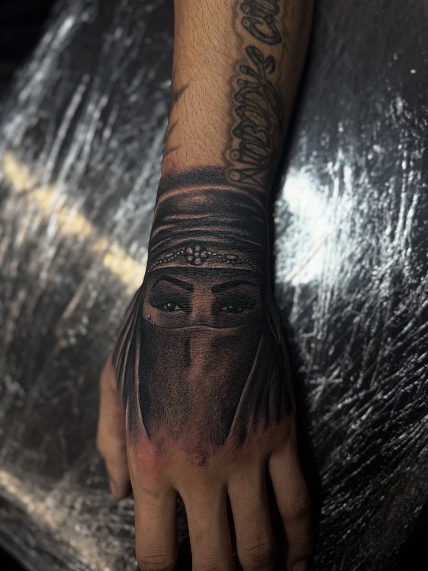 Woman wearing niqab realism tattoo on the hand by @samg_tat2s, San Diego, California
