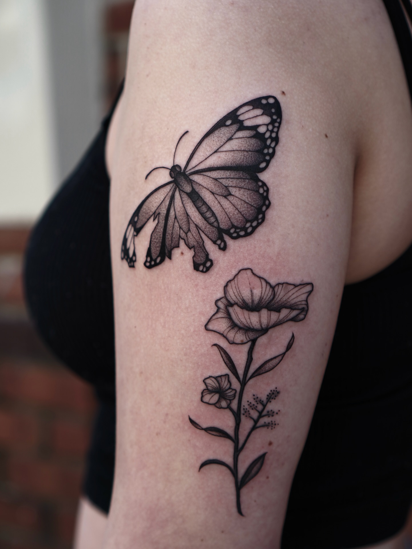 Butterfly and poppy dotwork tattoo on the forearm by Carlos Abad