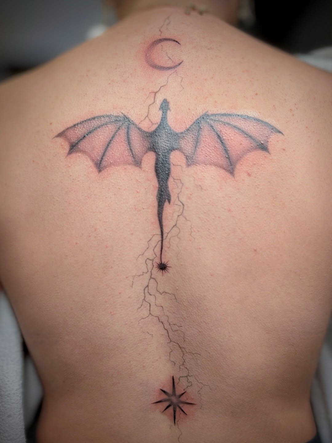Dragon black and grey tattoo on the back by Rhiannon