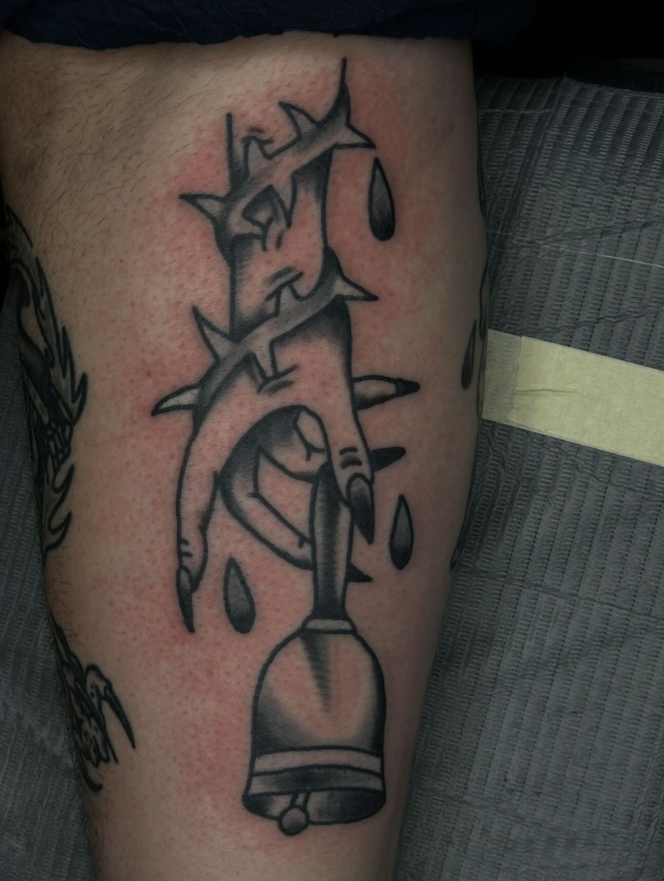 Bell and thorns black and grey tattoo on the thigh by Stephen Galena