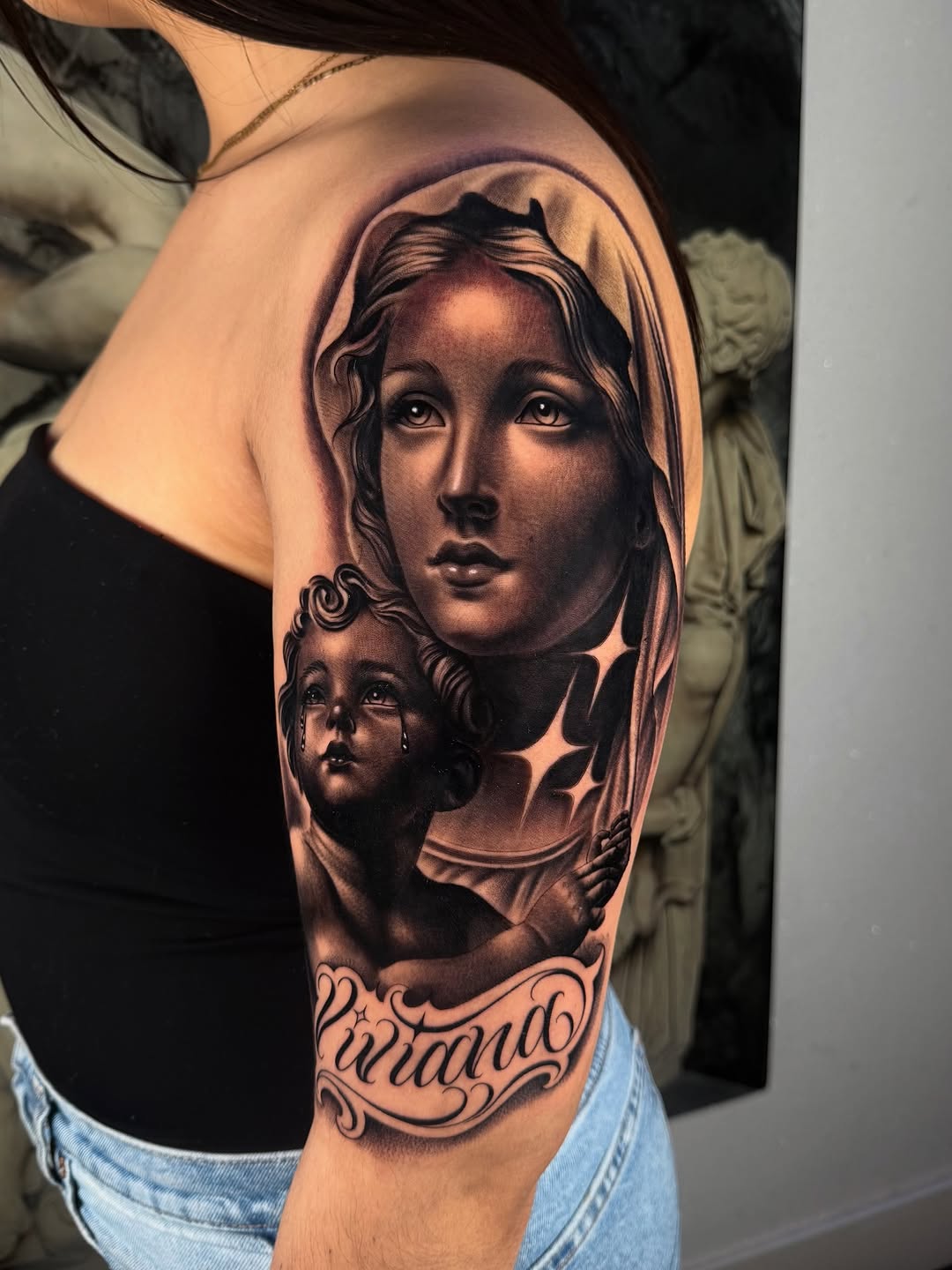 Virgin Mary and cherub with name Chicano tattoo on the shoulder by Fernando Andrade Jr