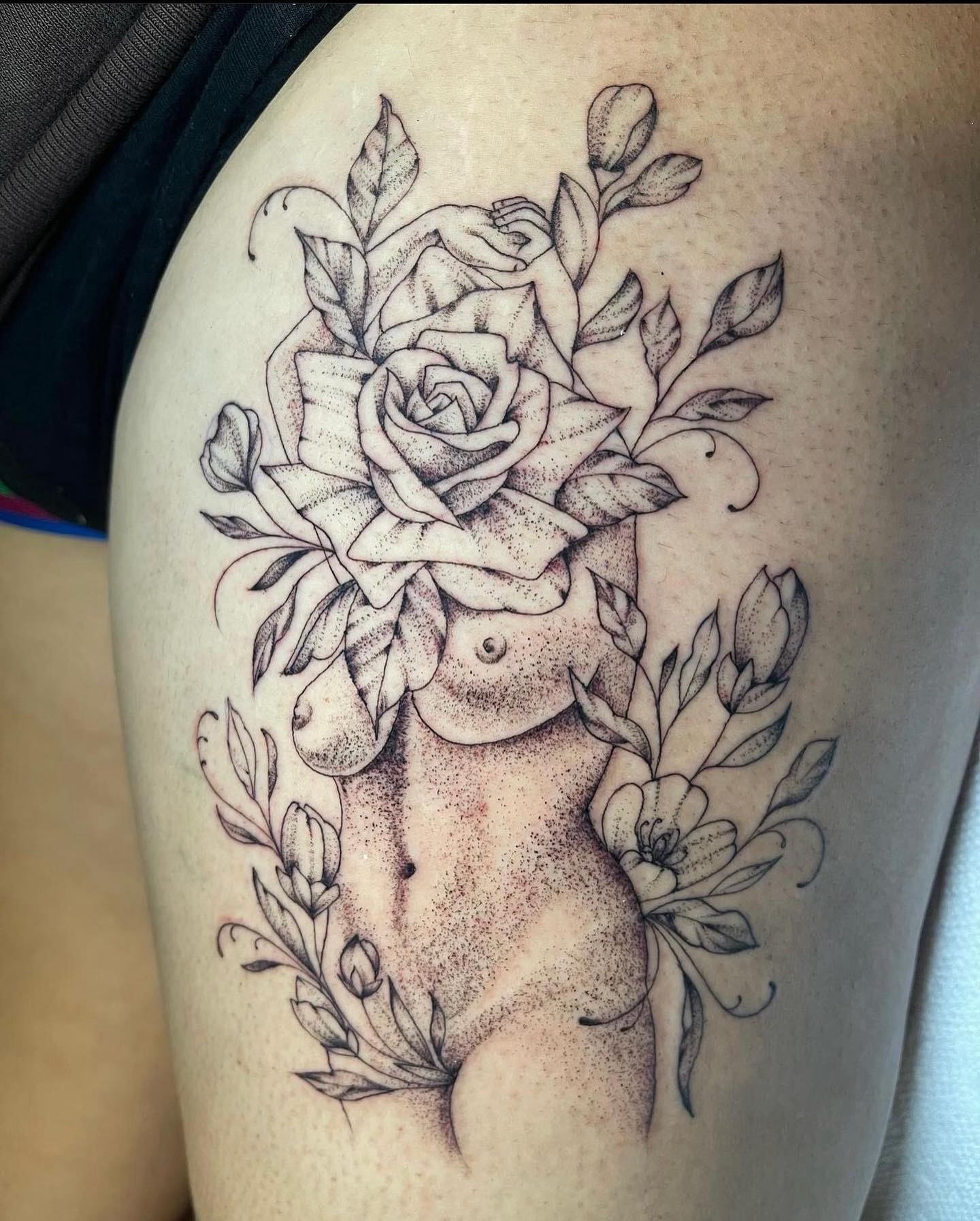 Nude torso with floral arrangement dotwork tattoo on the shoulder by Brandie