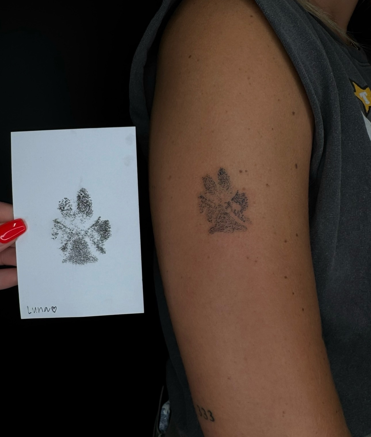 Paw print dotwork tattoo on the upper arm by Ryleigh Benjamin