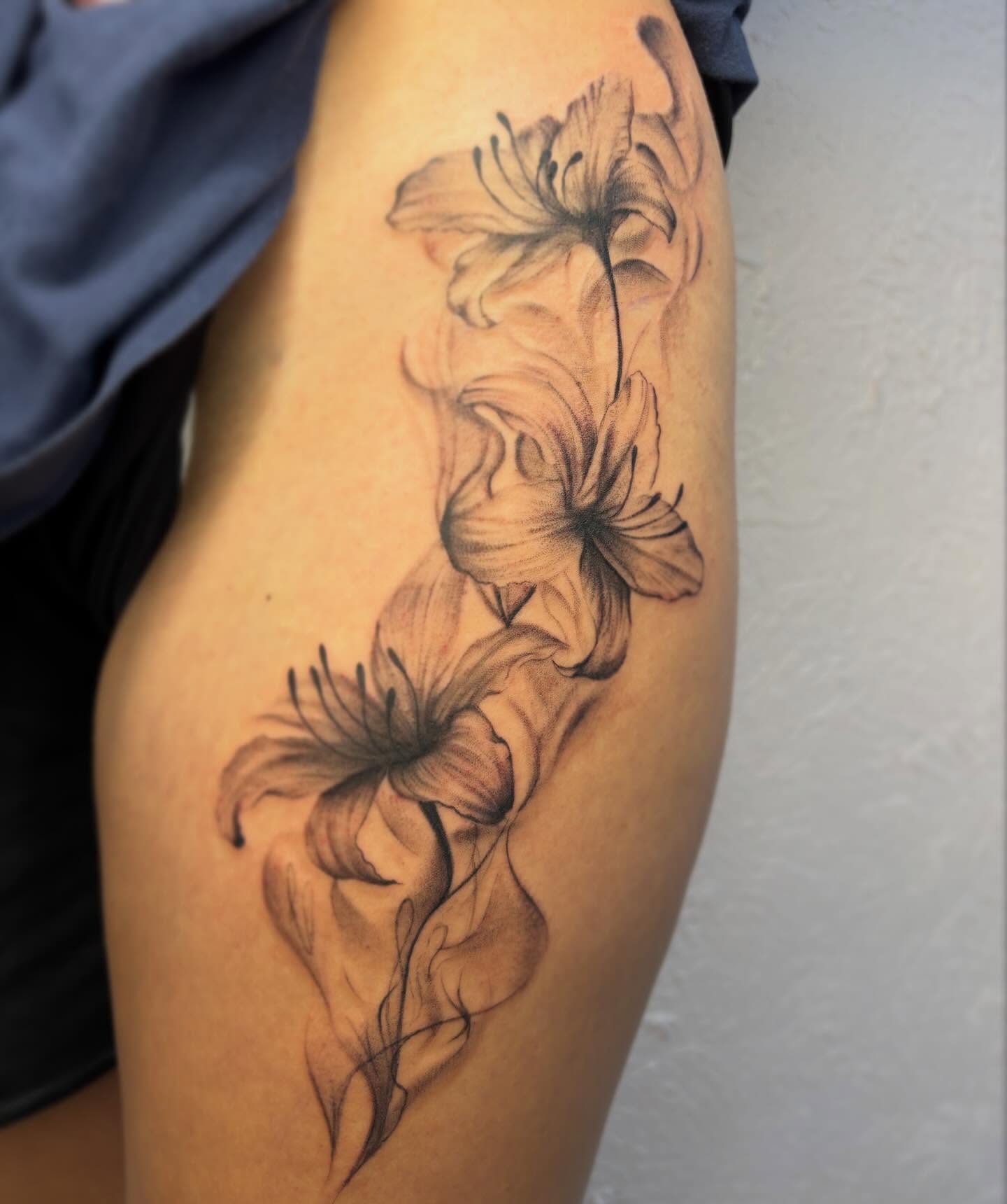 Lilies black and grey tattoo on the thigh by Jackie π€