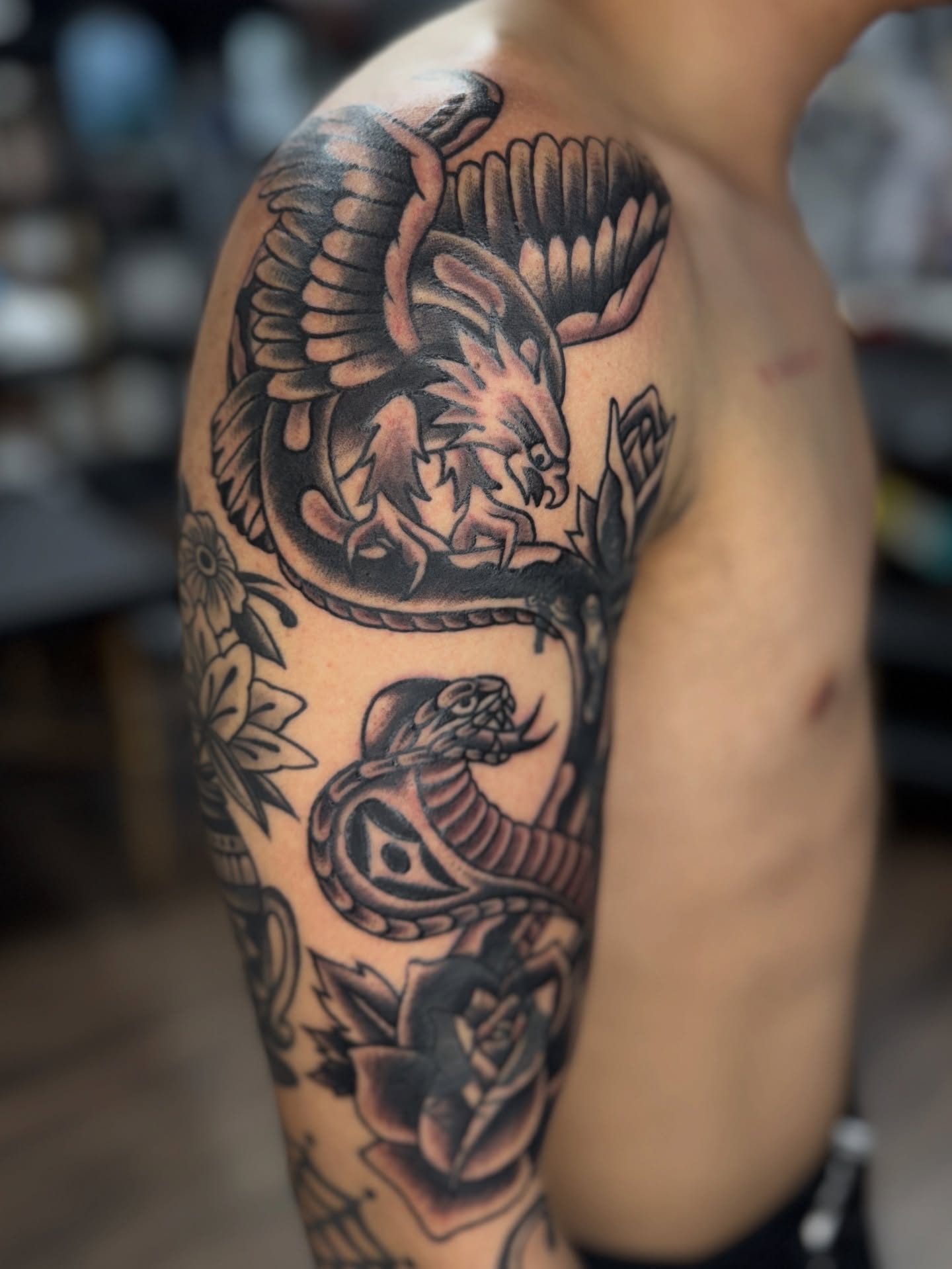 Snake and peony American traditional tattoo on the shoulder by Sarah Pham