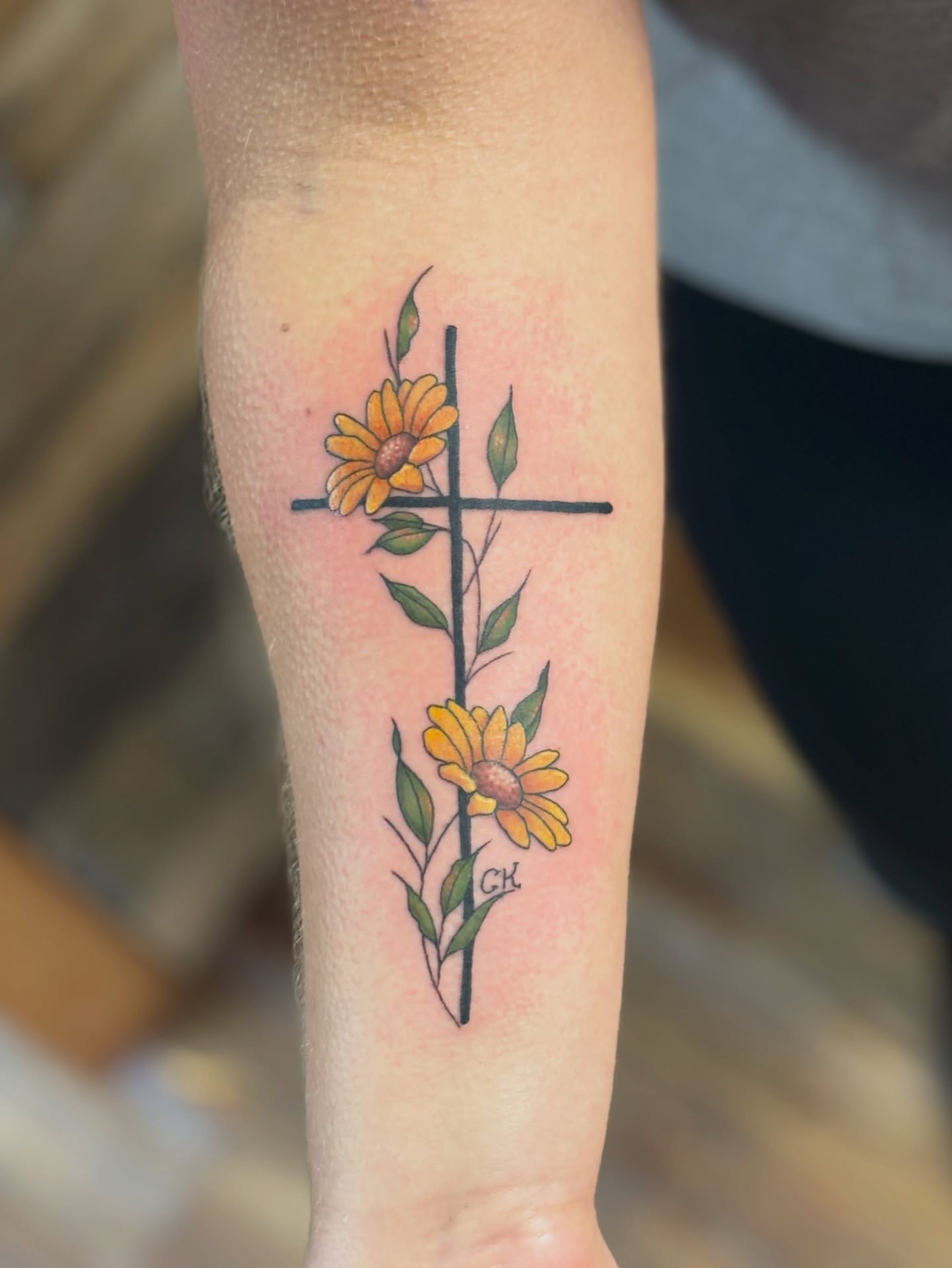 Sunflower cross neo-traditional tattoo on the forearm by MJ Saunders