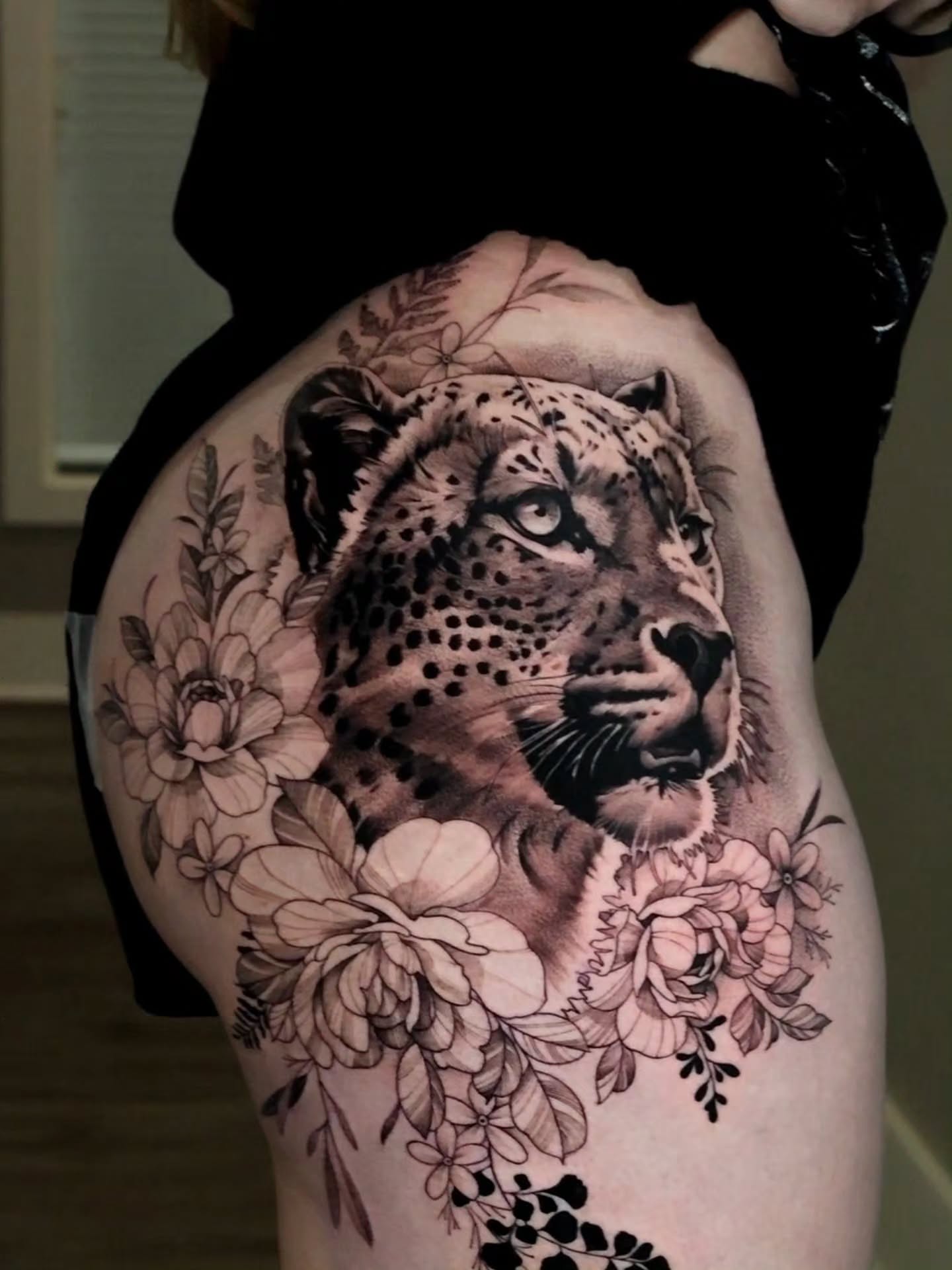 Snow leopard and floral realism tattoo on the thigh by Jesus Bravo