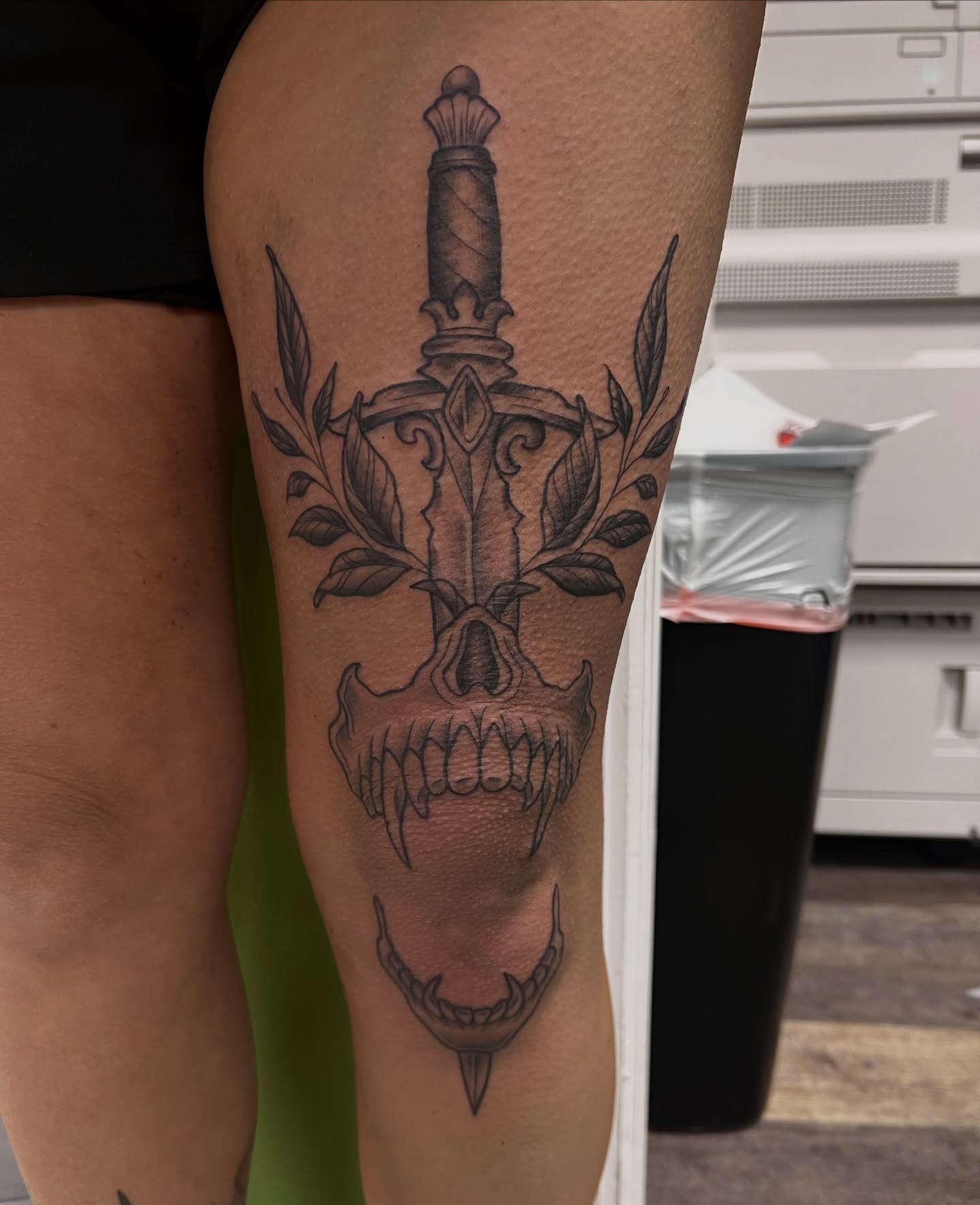 Skull with sword geometric tattoo on the calf by Olivia Suzanne Fada