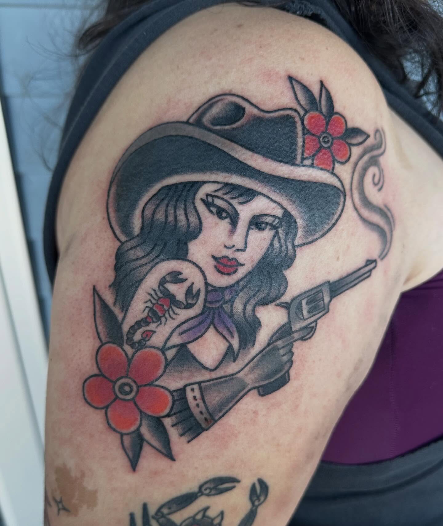 Cowgirl with revolver American traditional tattoo on the shoulder by Whitney Creep Tattoos