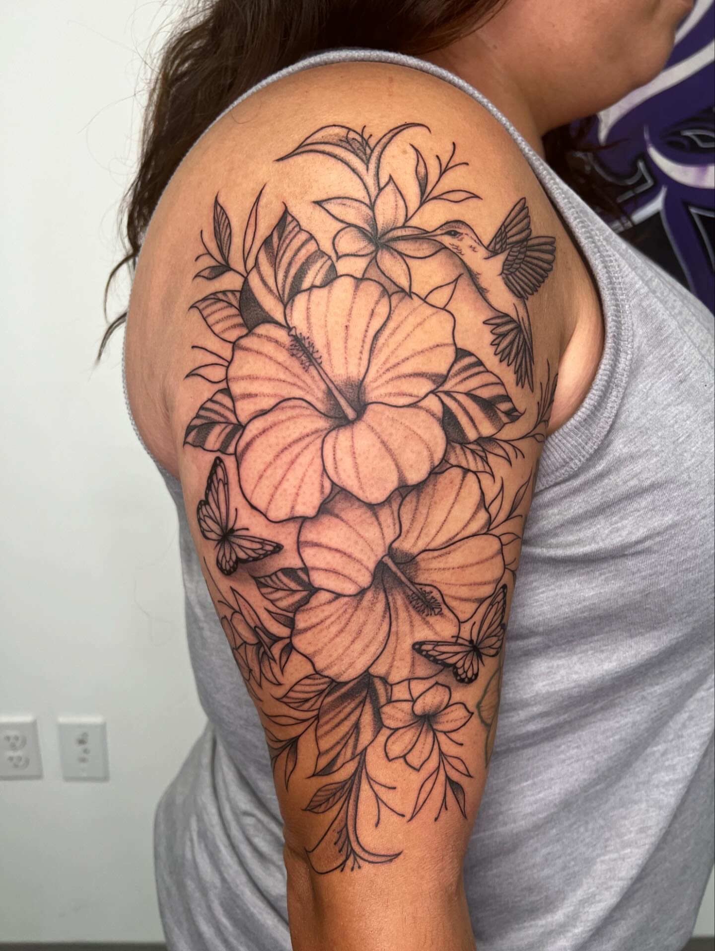 Hibiscus flowers and hummingbird realism tattoo on the shoulder by San Diego Fineline Black & Grey Tattoo Artist