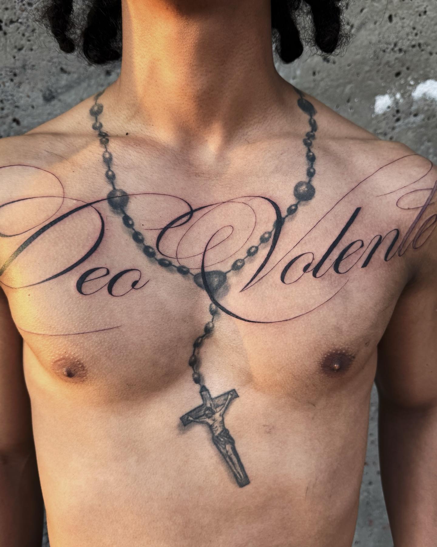 Rosary and script lettering script tattoo on the chest by viktoria raquel