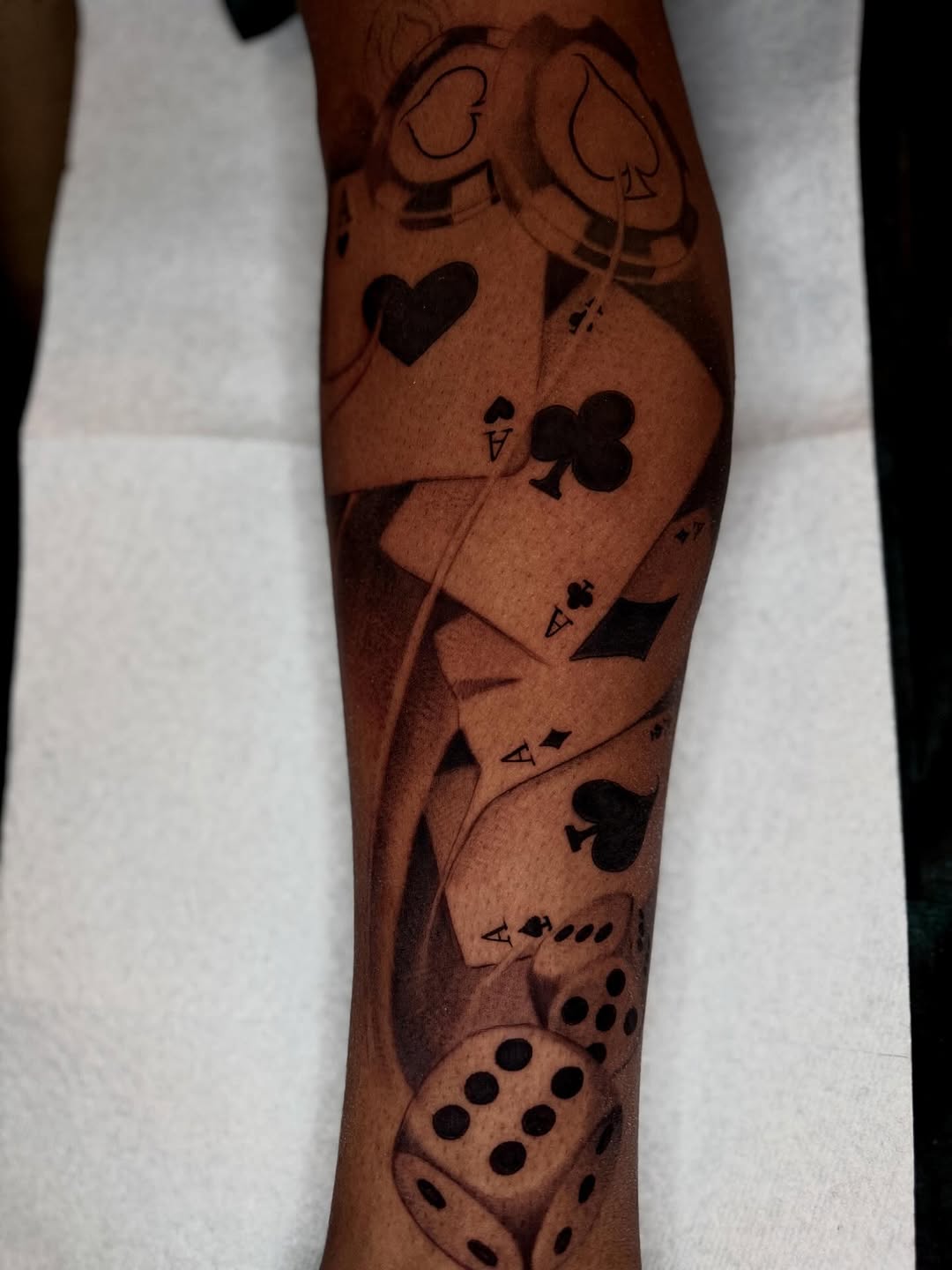 Playing cards and dice surrealism tattoo on the forearm by Angelo Buonanno, Las Vegas, Nevada