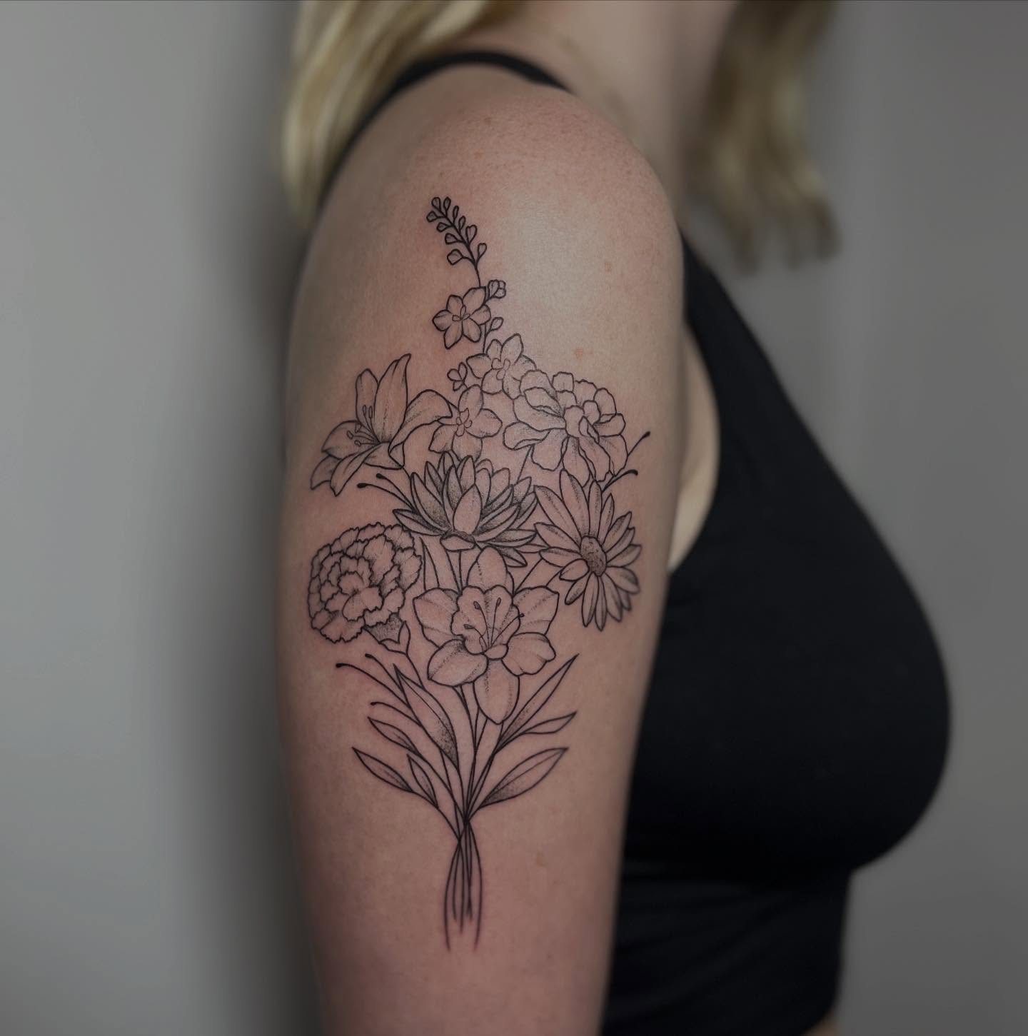 Flower bouquet black and grey tattoo on the upper arm by Ty’s Tattoos
