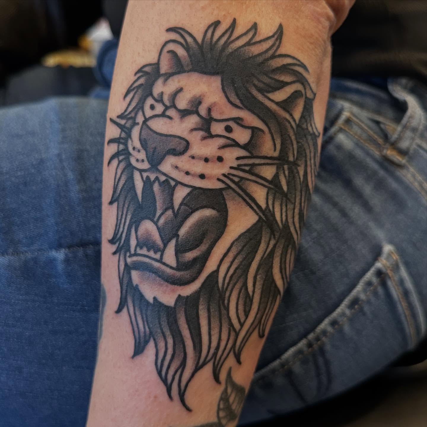 Lion black and grey tattoo on the forearm by Alexa Wolfkiel