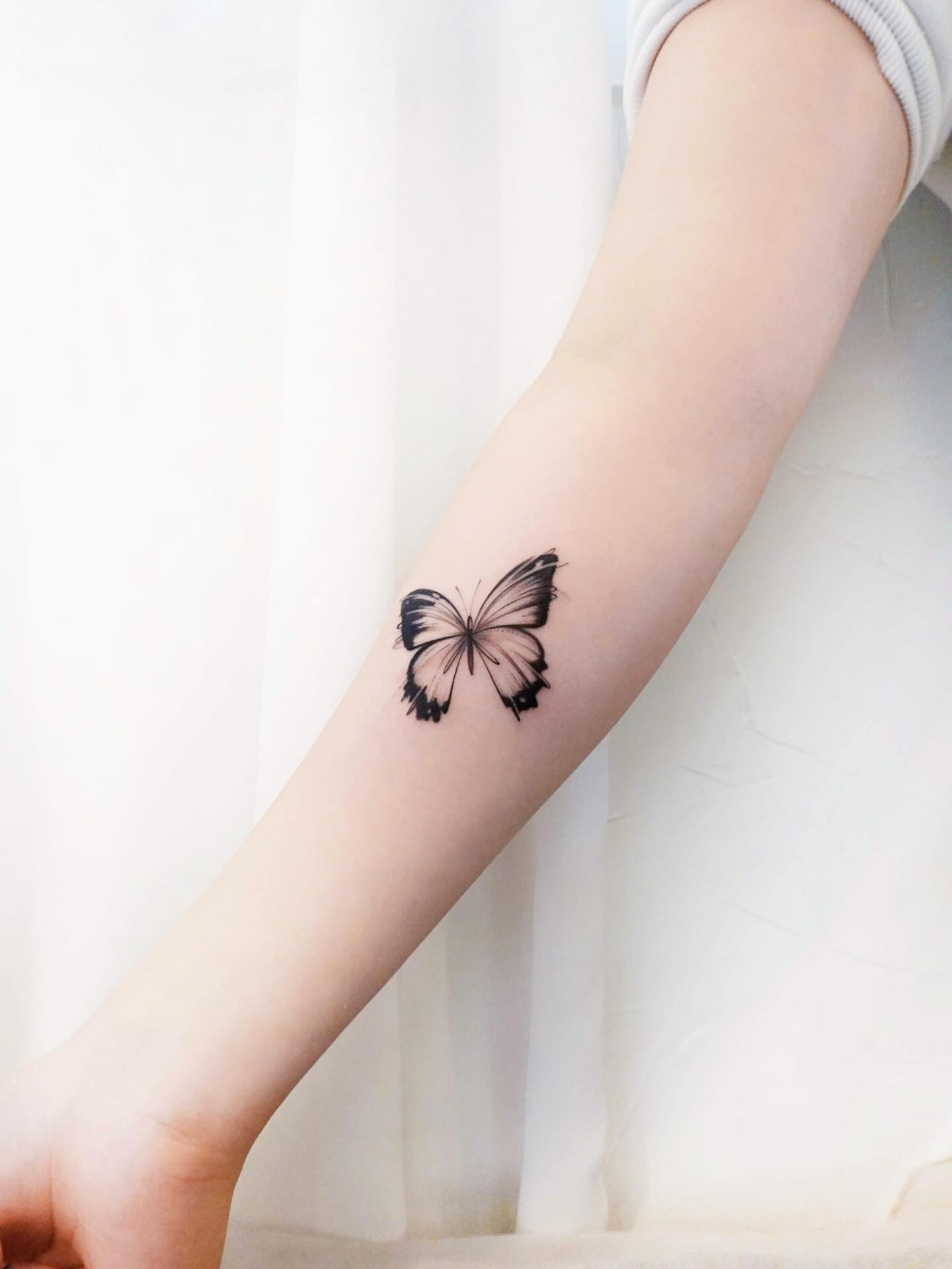 Butterfly black and grey tattoo on the forearm by 초현실과 현실 그 사이를 그리다.