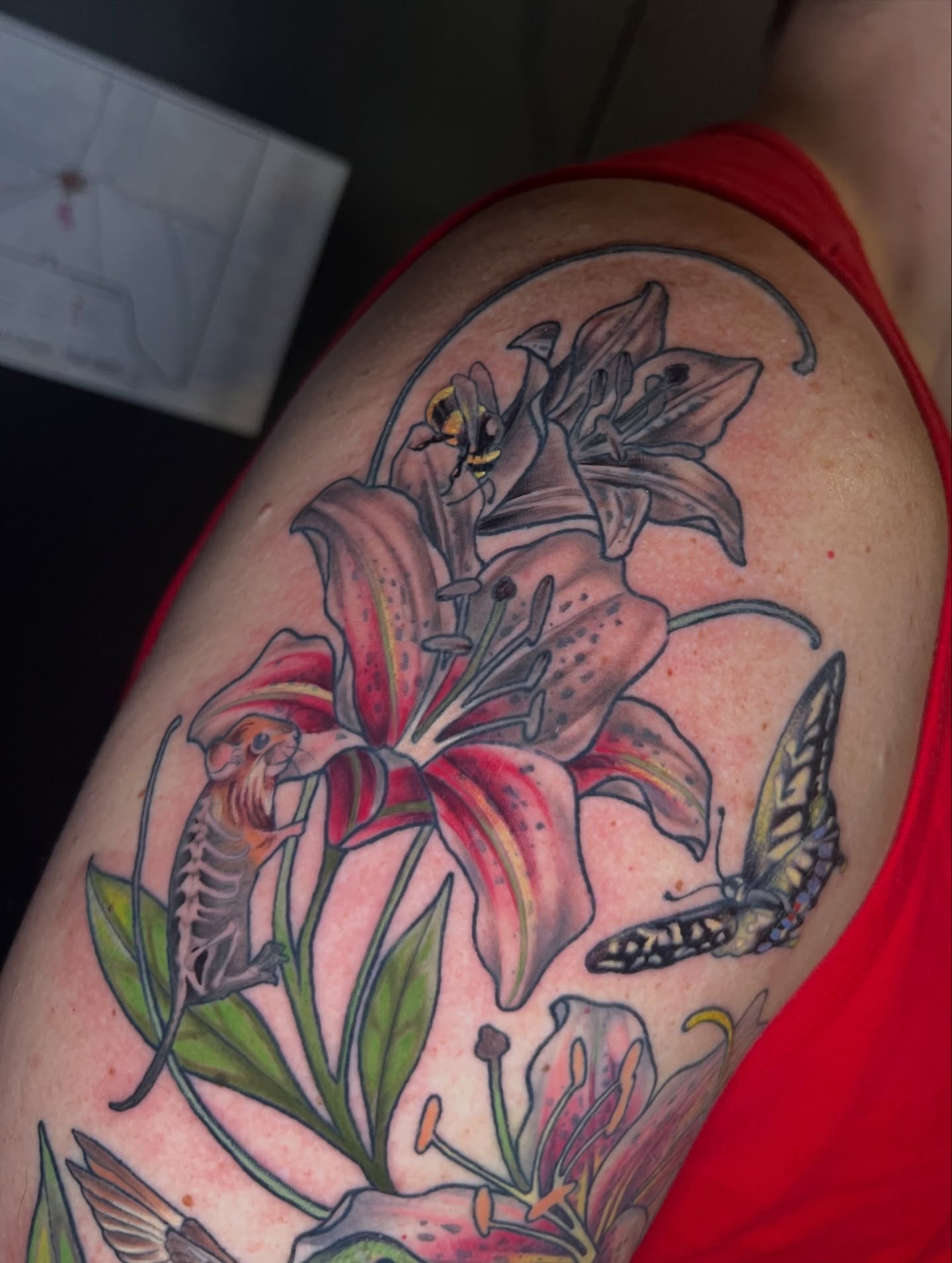 Lilies and insects realism tattoo on the shoulder by Belle Halverson