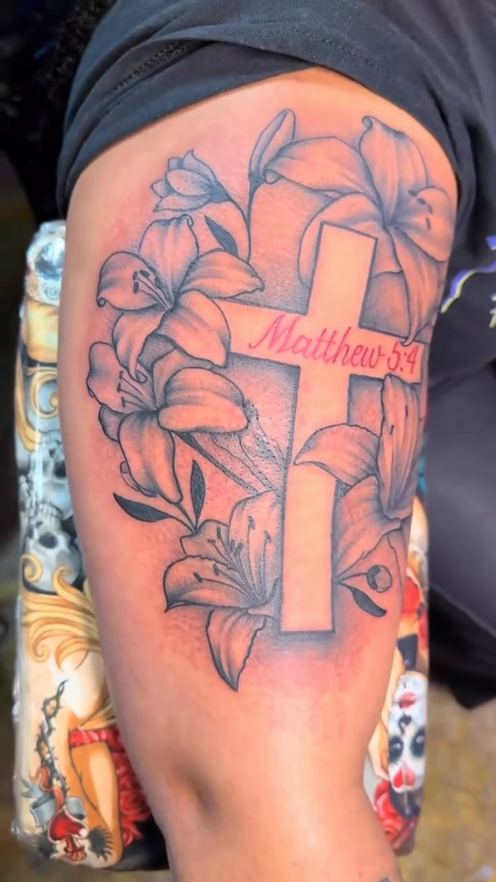 Cross with lilies and scripture fine line tattoo on the back by Teddi James, Renton, Washington