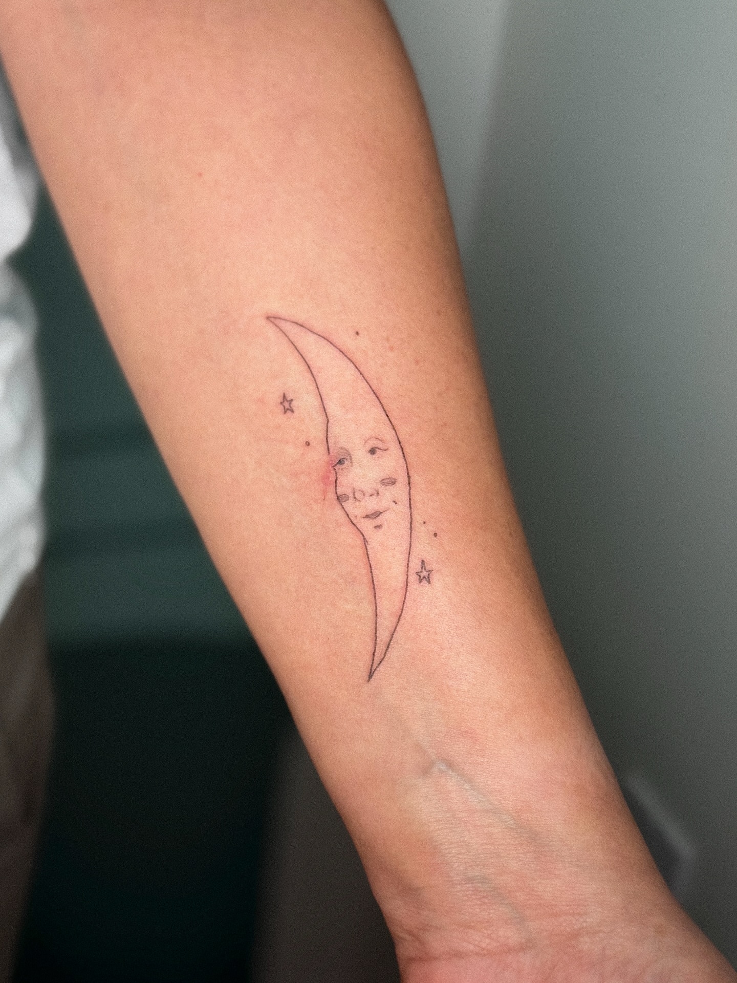 Moon and face fine line tattoo on the forearm by madison