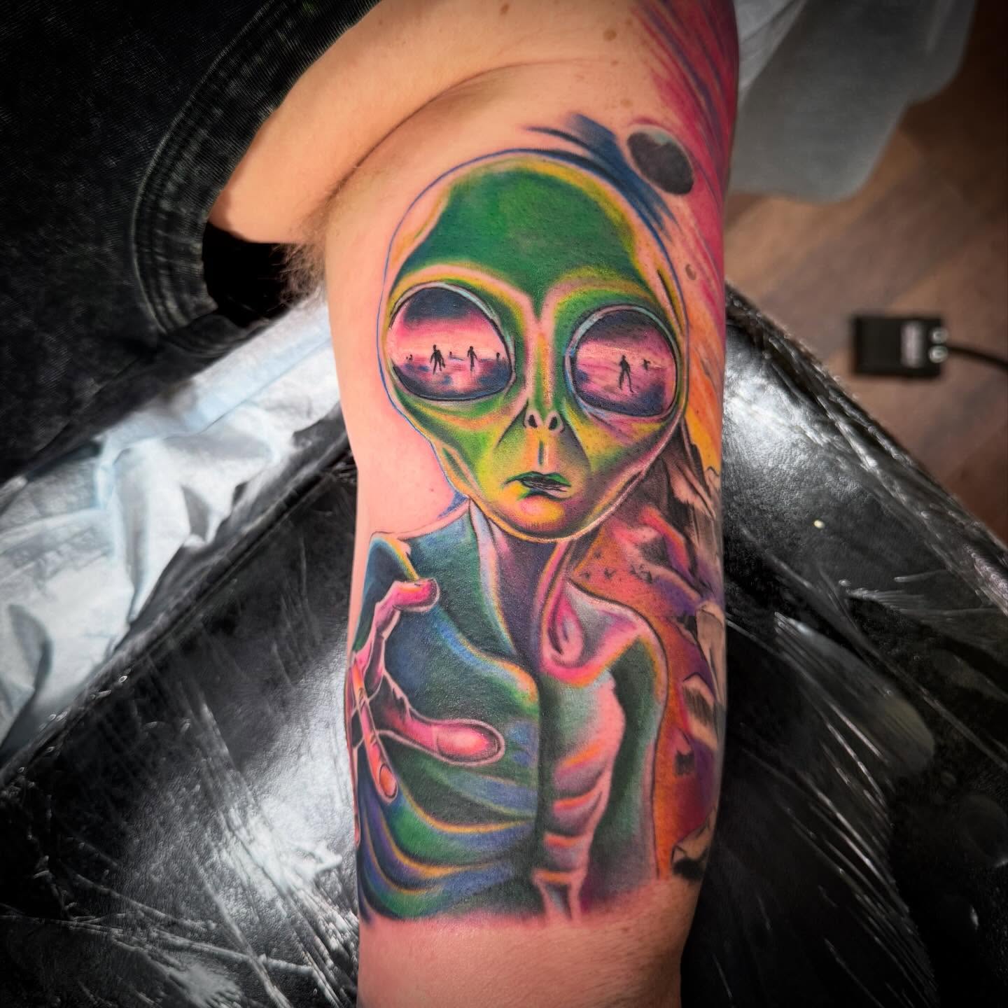 Alien illustrative tattoo on the forearm by Tanner Pastor