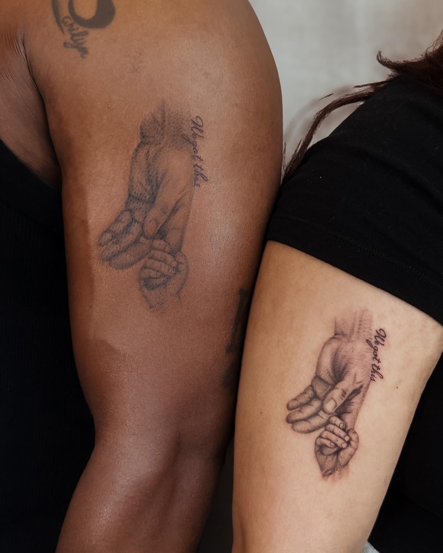 Hands holding baby dotwork tattoo on the forearm by Koko