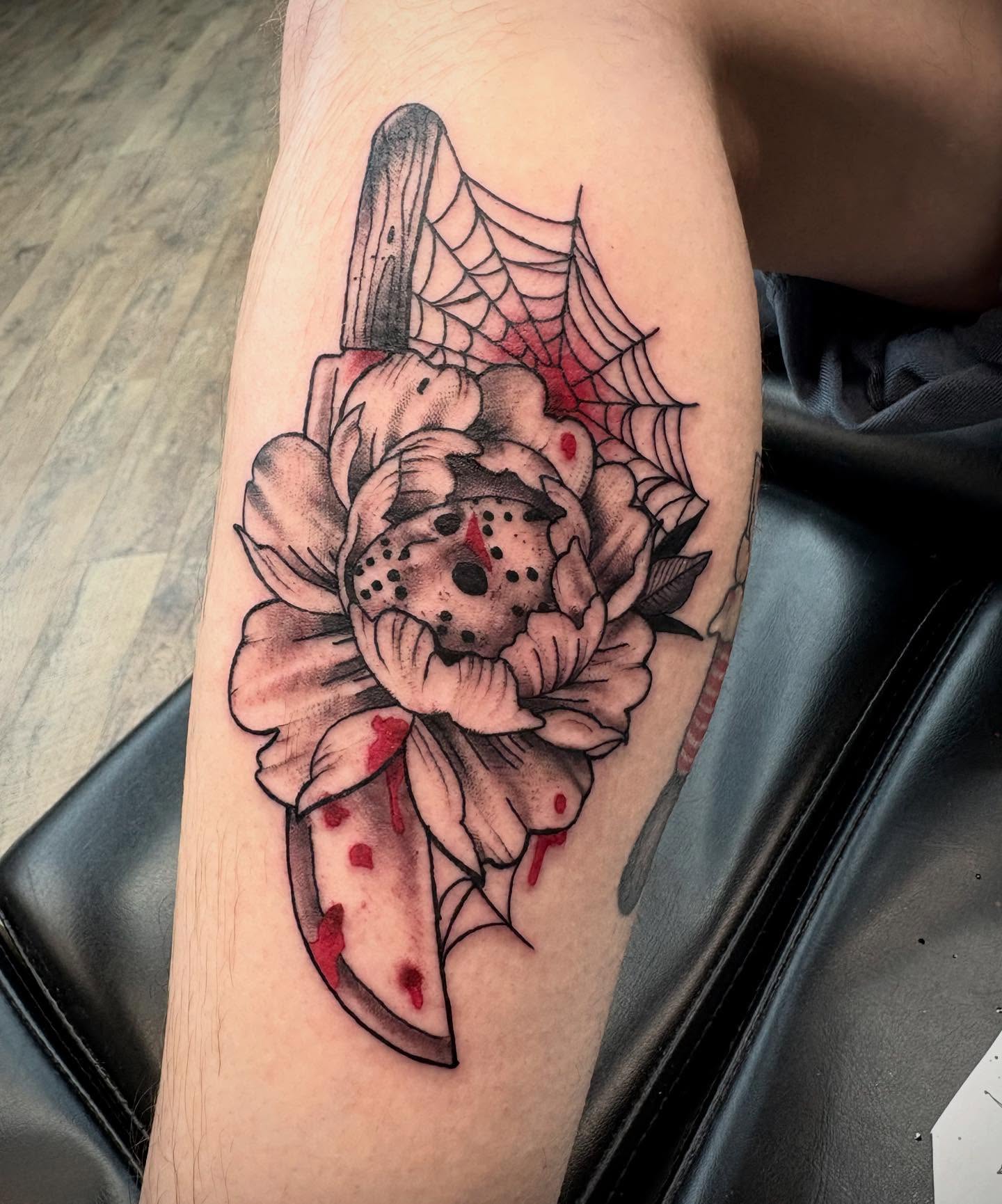 Flower with knife trash polka tattoo on the forearm by Robbie Reel, Wichita, Kansas