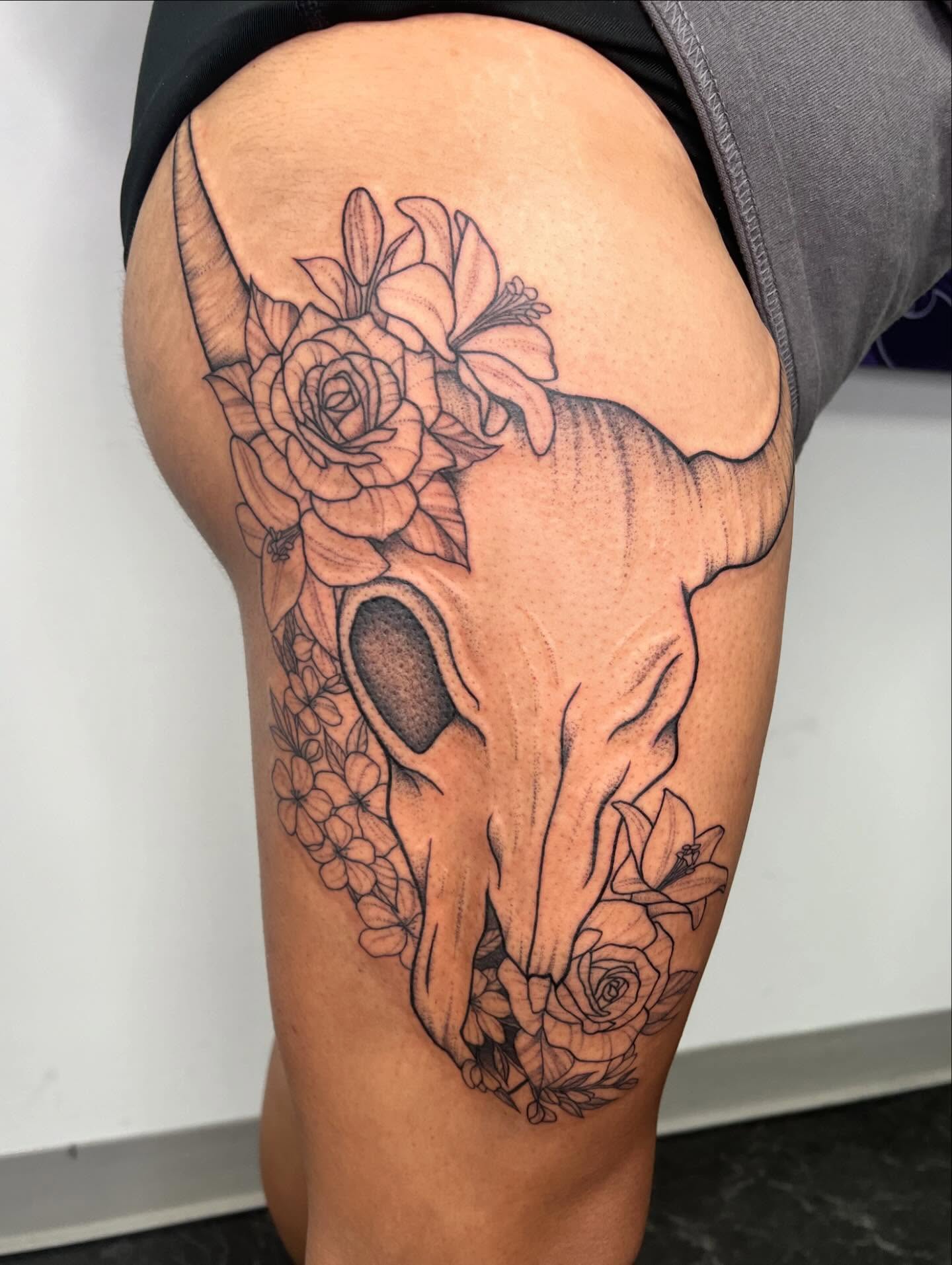 Bull skull with flowers black and grey tattoo on the thigh by San Diego Fineline Black & Grey Tattoo Artist