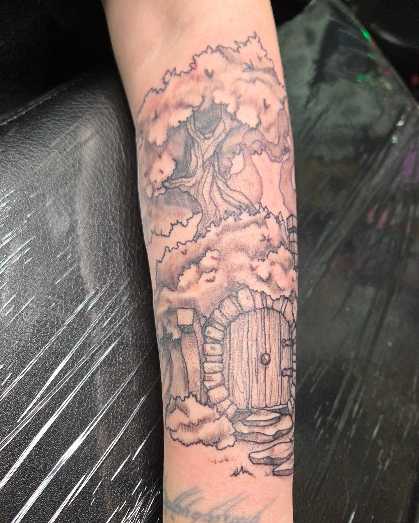 Tree house black and grey tattoo on the forearm by Trinity Renee